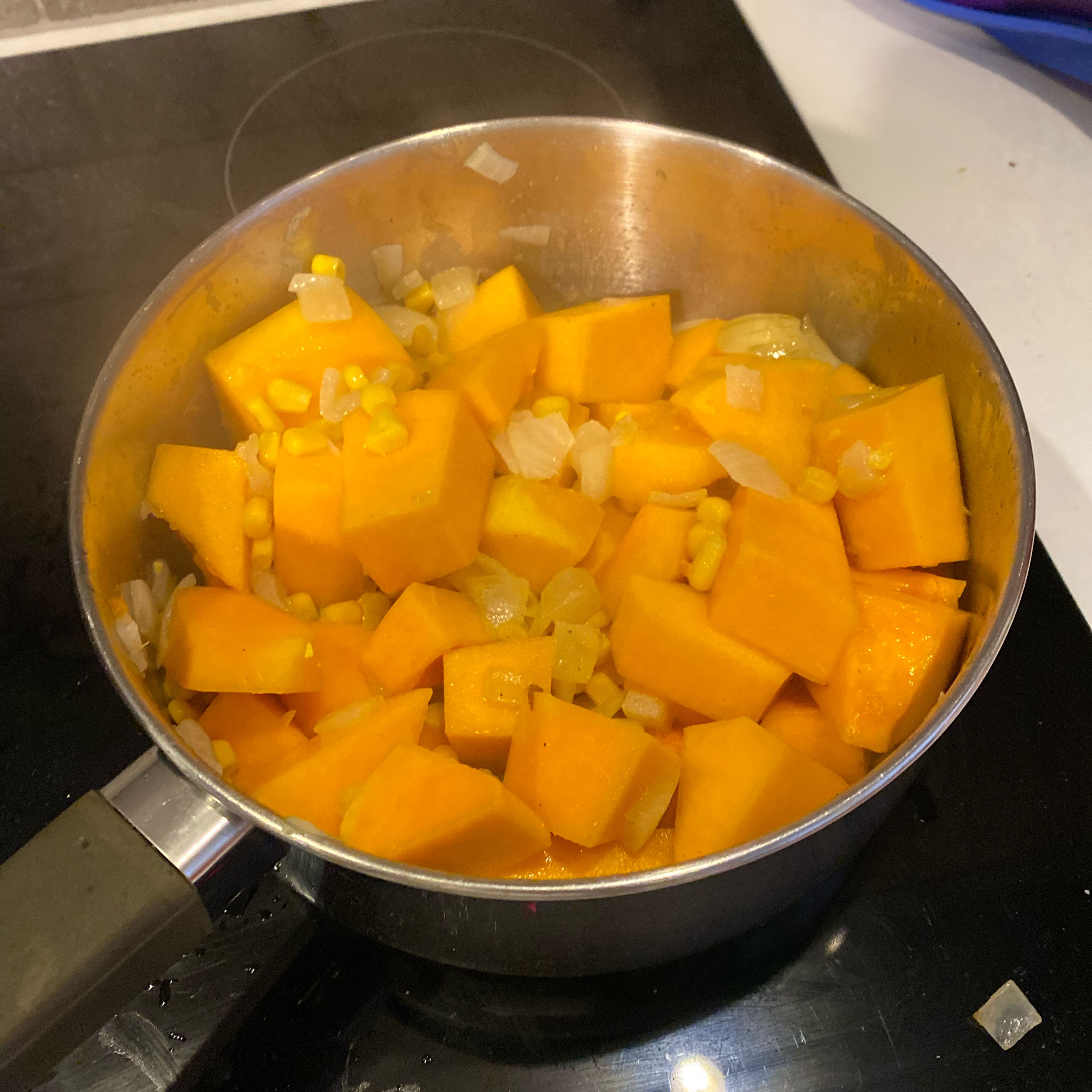 Add the chopped butternut squash and sweetcorn. Stir and season with salt and pepper. Cook on medium heat for about 10 minutes with the lid on.