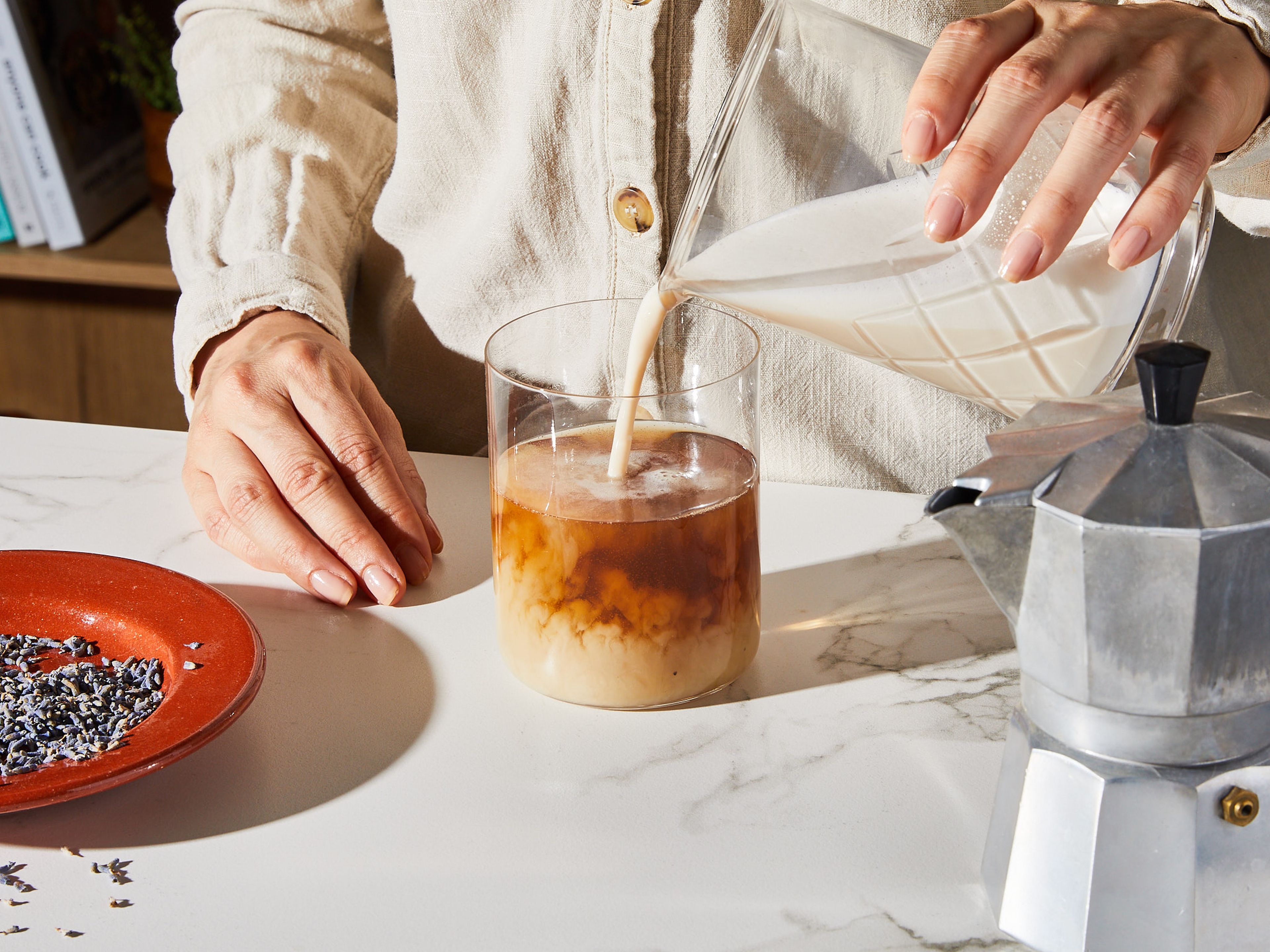 Zum Kombinieren zuerst vorsichtig und langsam den Schaum und danach den Espresso in den Tee gießen, sodass sich nicht alles sofort vermischt. Mit Lavendelblüten oder losem Earl Grey Tee garnieren und vor dem Trinken umrühren.