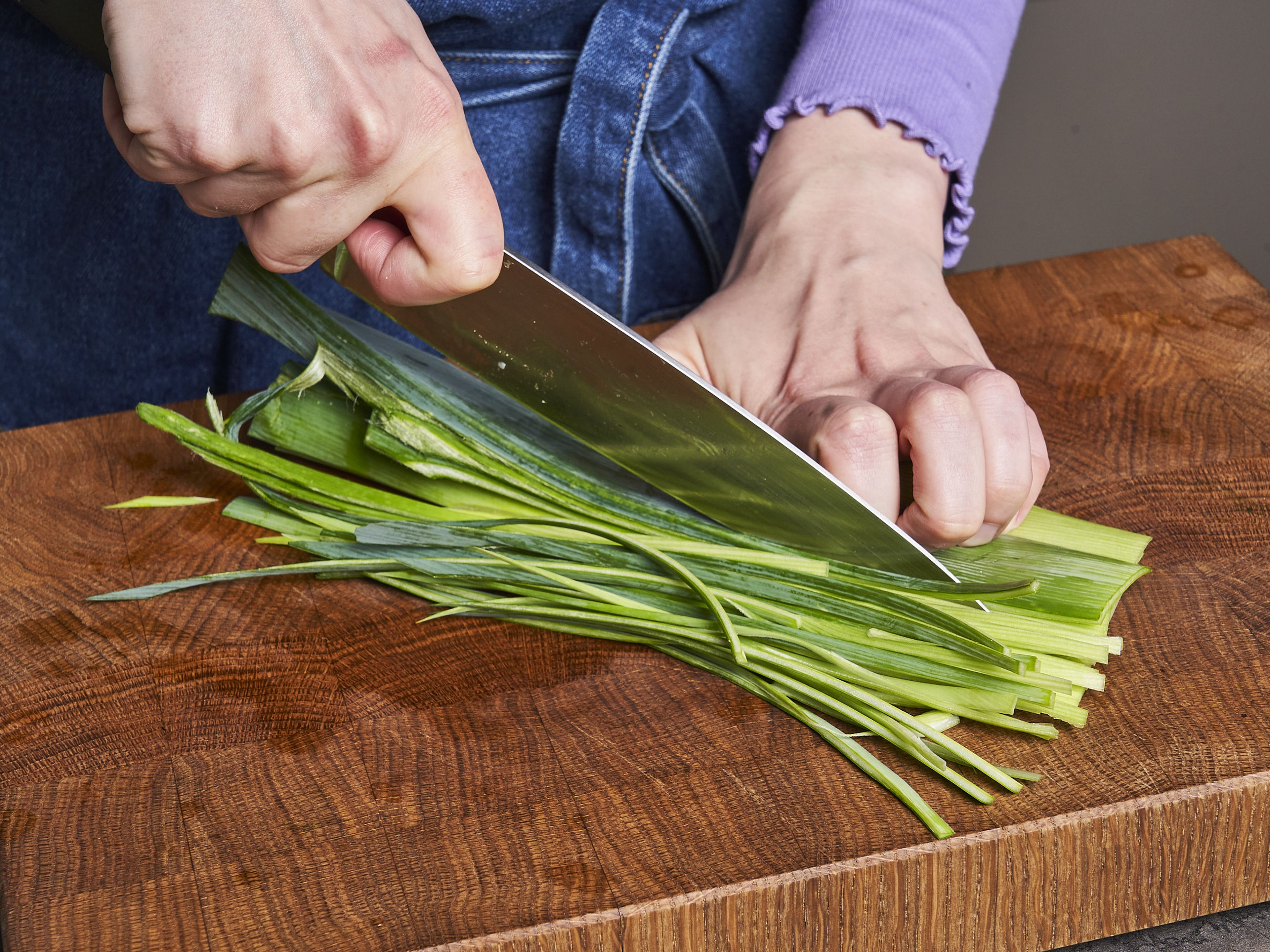 Separate the white and the green of the leek. Halve the whites lengthwise, wash well, and slice thinly. Wash the greens as well, stack them, and cut into thin, long, spaghetti like strips. Prepare a pot of water for pasta and set to boil. Grate the parmesan.