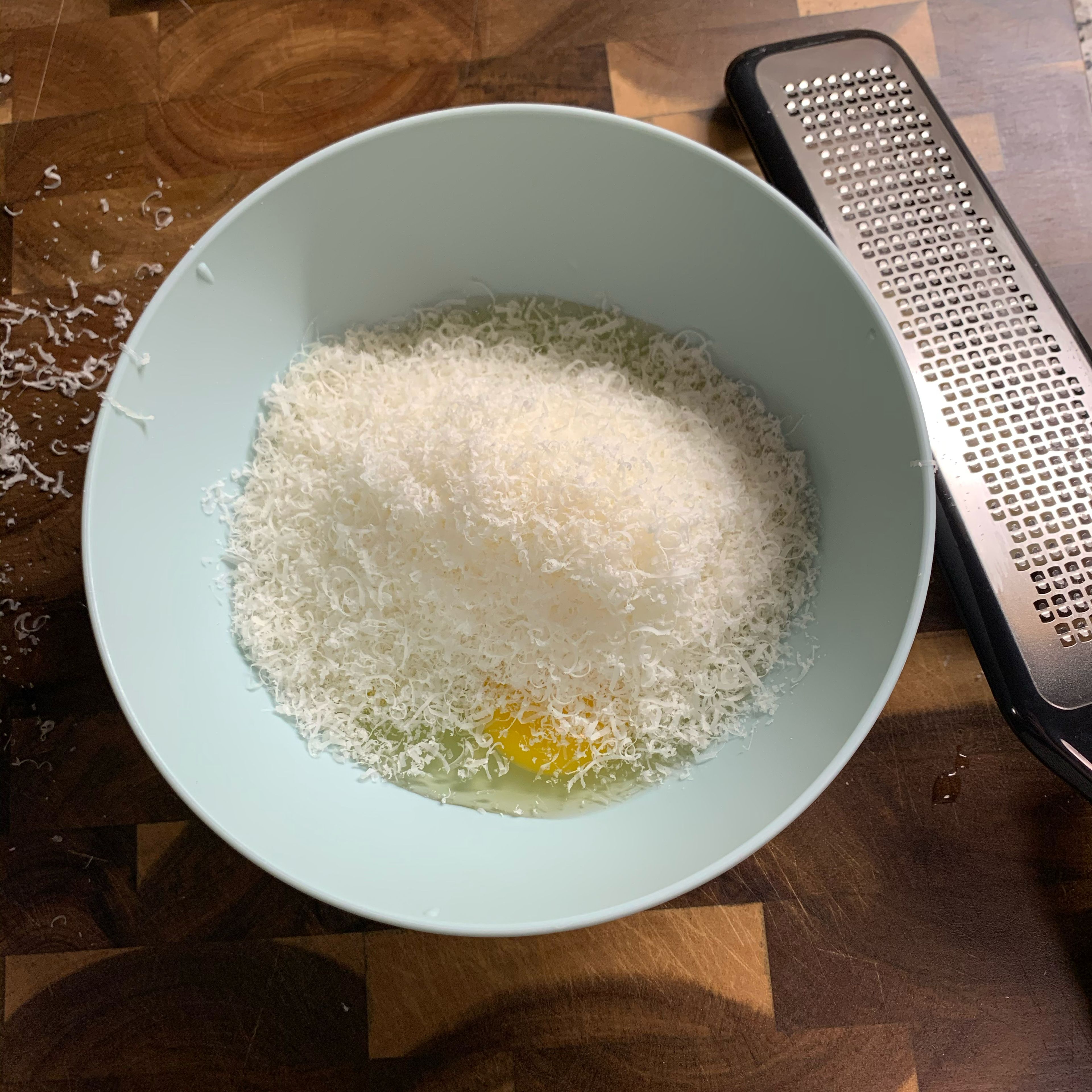 Add 3 eggs and grated Parmesan cheese into a bow. It’s not scientific how much to put in, more cheese can be added later. Use a microplane or the smallest size of a grater.
