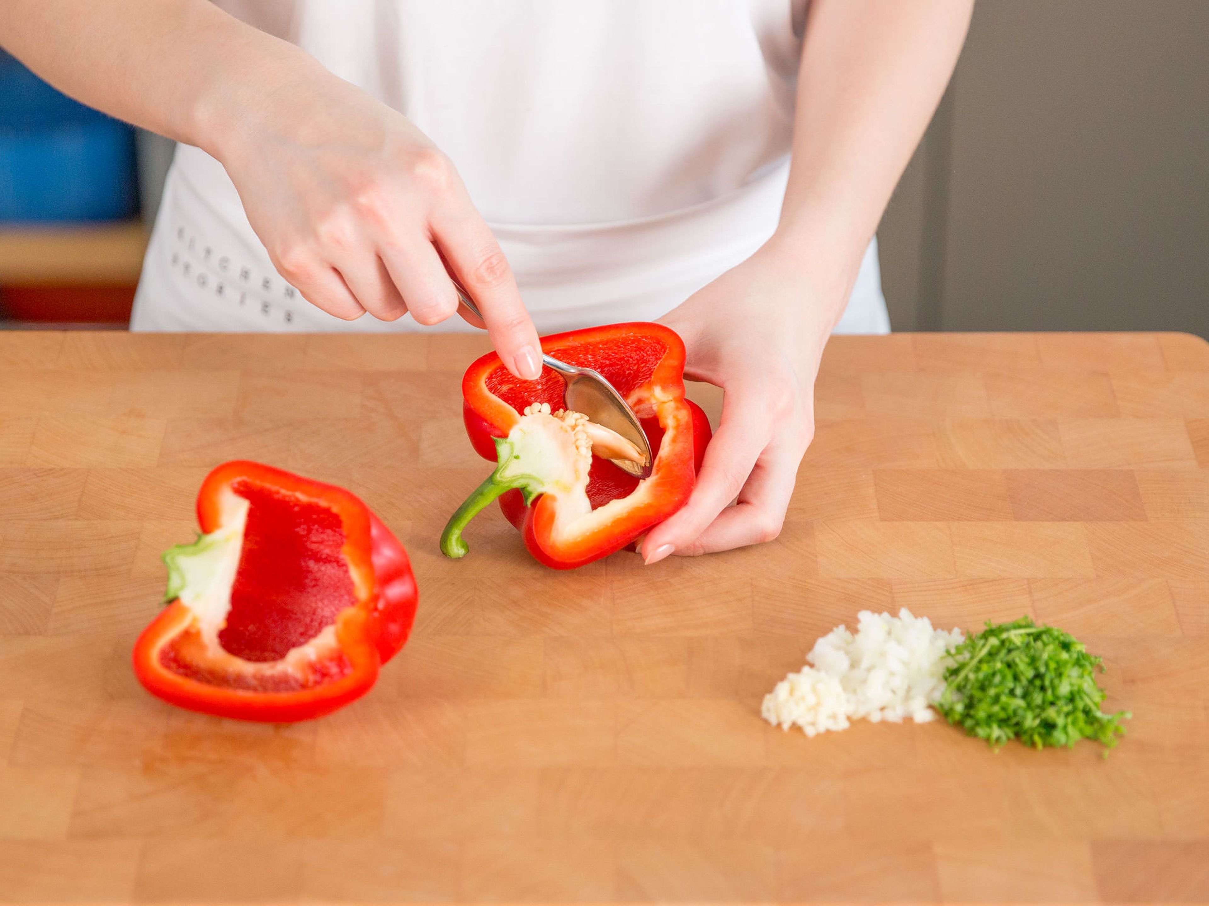 Finely chop onion and garlic into small pieces. Chop marjoram and parsley. Cut peppers in half and remove cores with the help of a spoon. Pre-heat oven to 160°C/320°F.