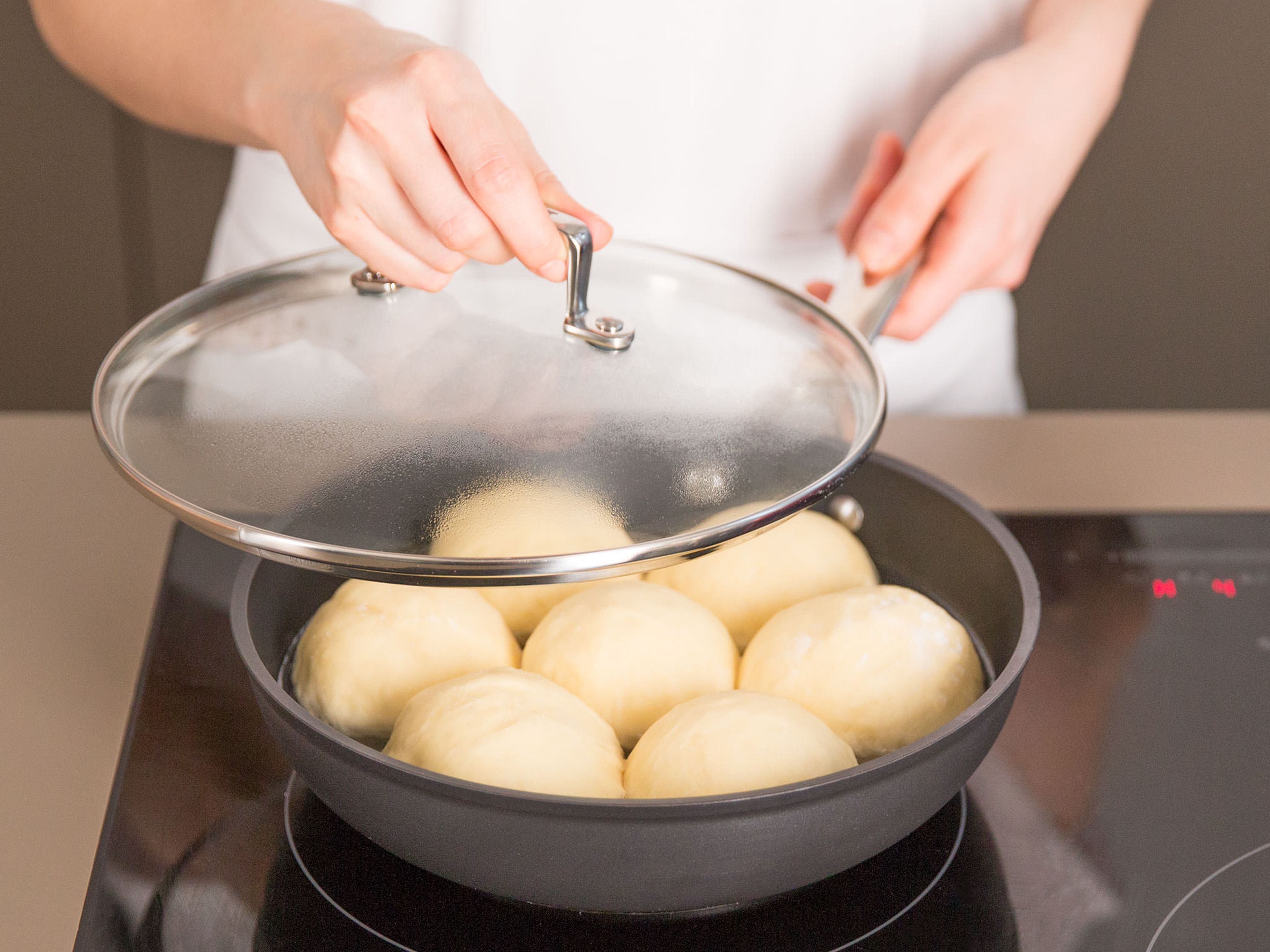 In a large frying pan, bring water, main part of salt, and oil to a low boil over medium heat. Add rolls, reduce heat to low, and cook covered for approx. 15 – 20 min. Remove from heat and transfer rolls to a serving platter and drizzle vanilla sauce on top. Enjoy!