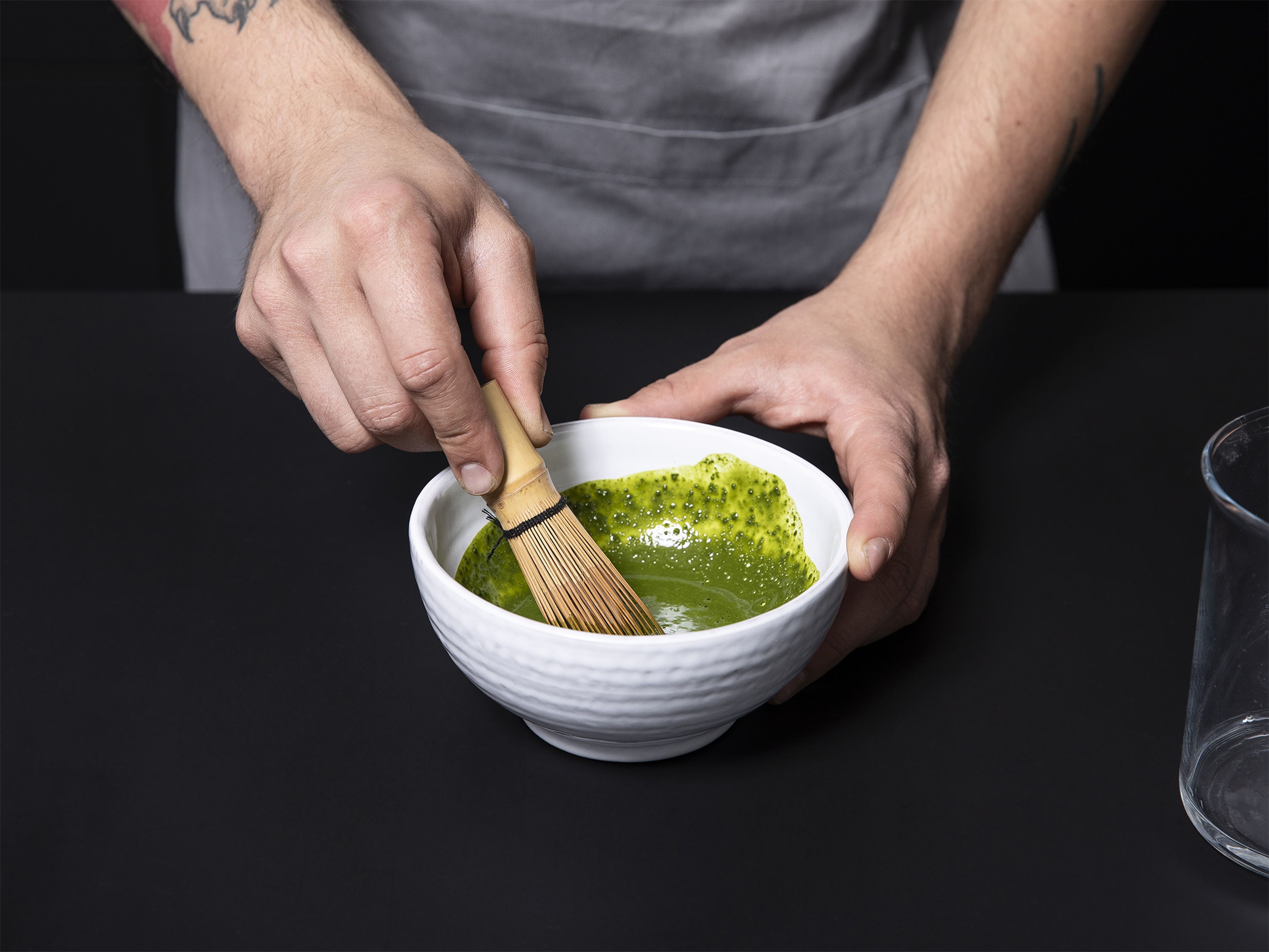 Add matcha powder to a small bowl. Use a matcha whisk to mix matcha with some hot water until smooth. Once smooth, add the rest of the hot water.