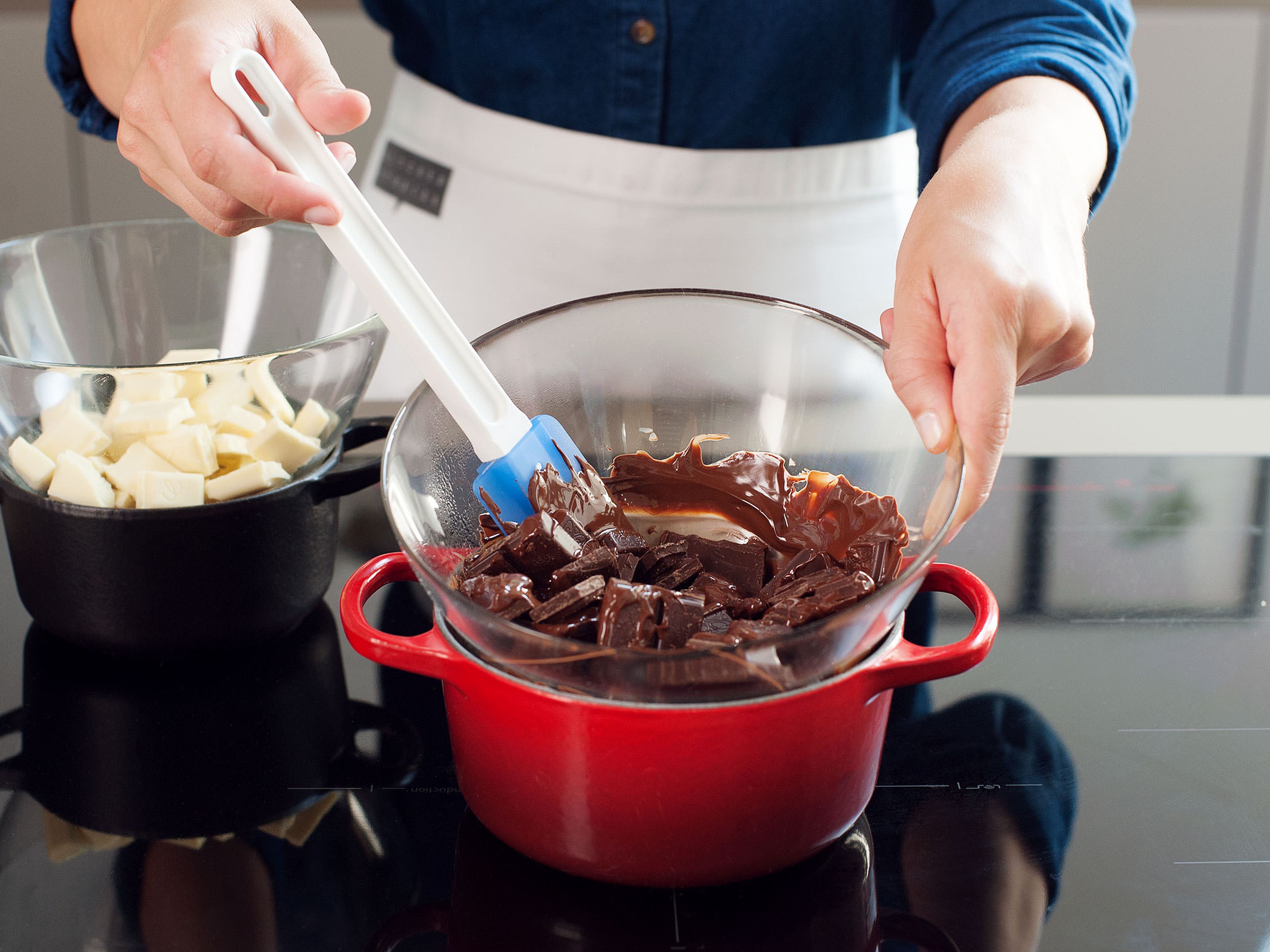 Add ¾ of the dark chocolate to a heatproof bowl and set it over a saucepan filled with simmering water. Stir chocolate with a rubber spatula occasionally until melted and smooth. Remove from heat and stir in remaining chocolate until just melted. Pour melted chocolate onto prepared baking sheet and spread evenly until about ½-cm/¼-in thick.