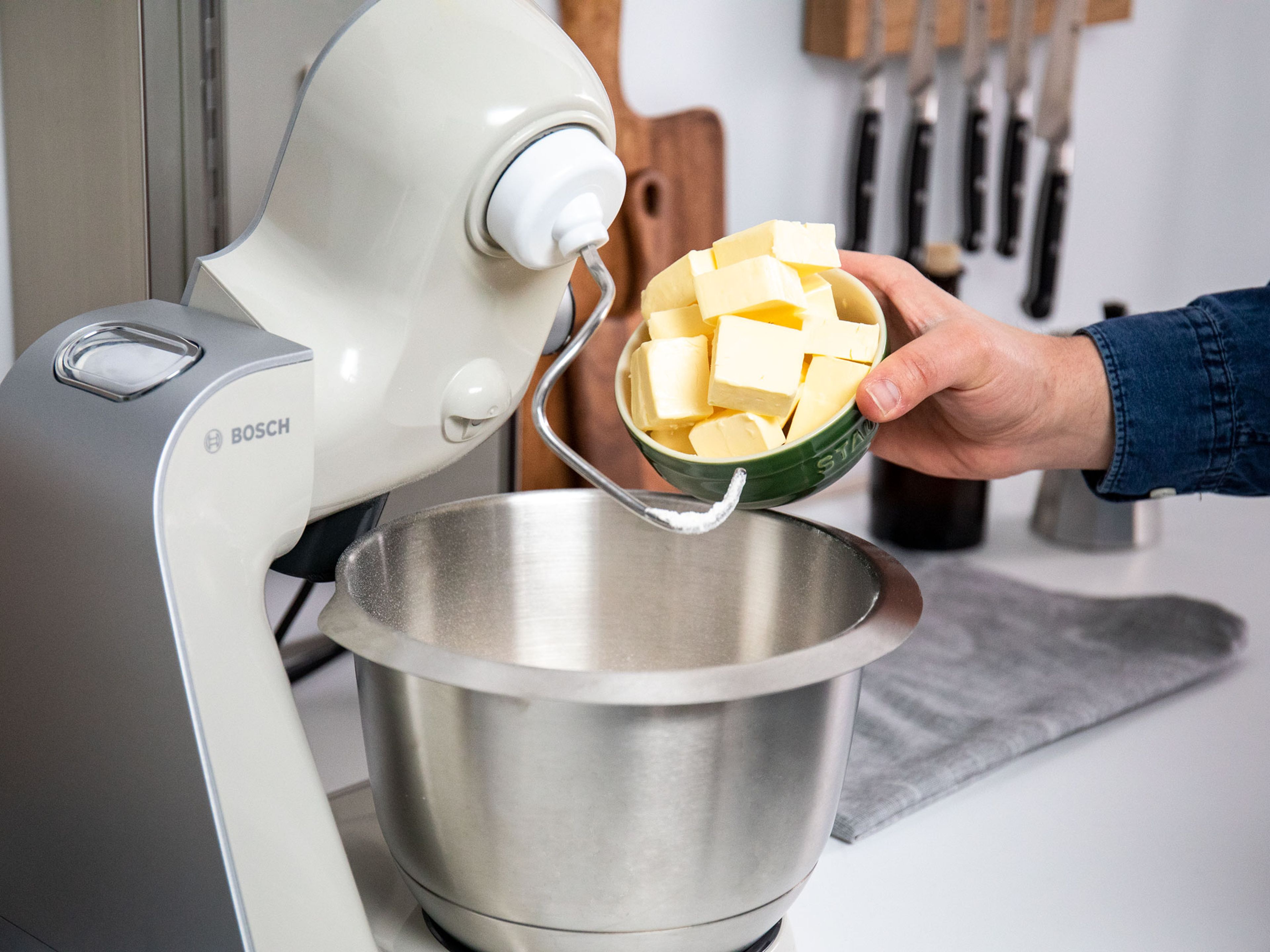 Backofen auf 180°C vorheizen. Mehl, einen Teil des Zuckers und Butter in die Schüssel einer Küchenmaschine geben und zu einem krümeligen Teig verarbeiten.