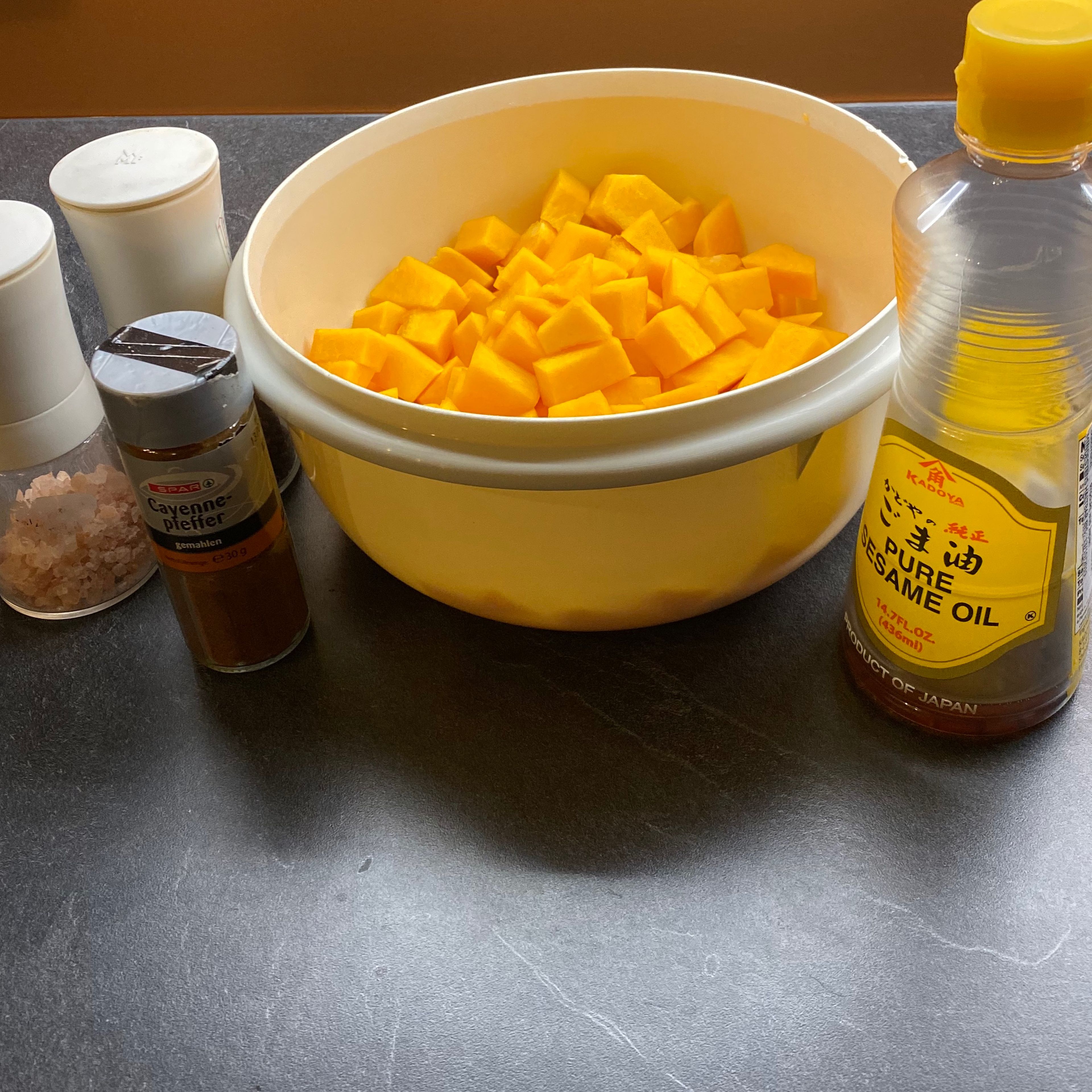 Kürbis mit Öl, Cayenne Pfeffer, Salz und Pfeffer vermengen und auf dem Backblech verteilen. Im heißen Ofen ca. 30 Minuten backen.