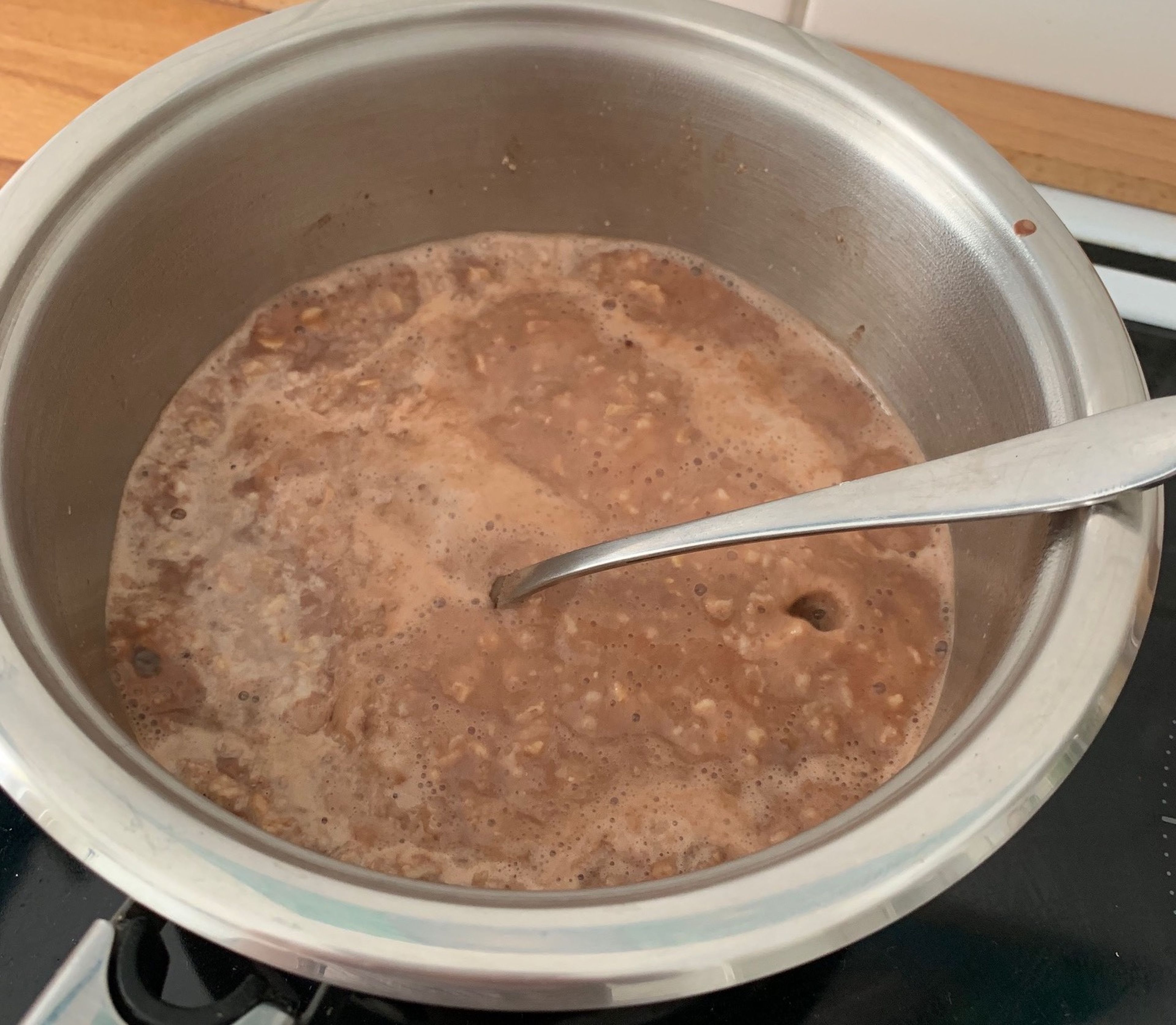 Für den Schoko-Porridge Haferflocken, Milch und Wasser in den Kochtopf geben. Bei mittlerer Hitze und regelmäßigem Umrühren aufkochen lassen (3 Min). Herd ausschalten und Porridge bei Restwärme weiterköcheln lassen. Raw Kakao unterrühren und 5 Min. ruhen lassen.