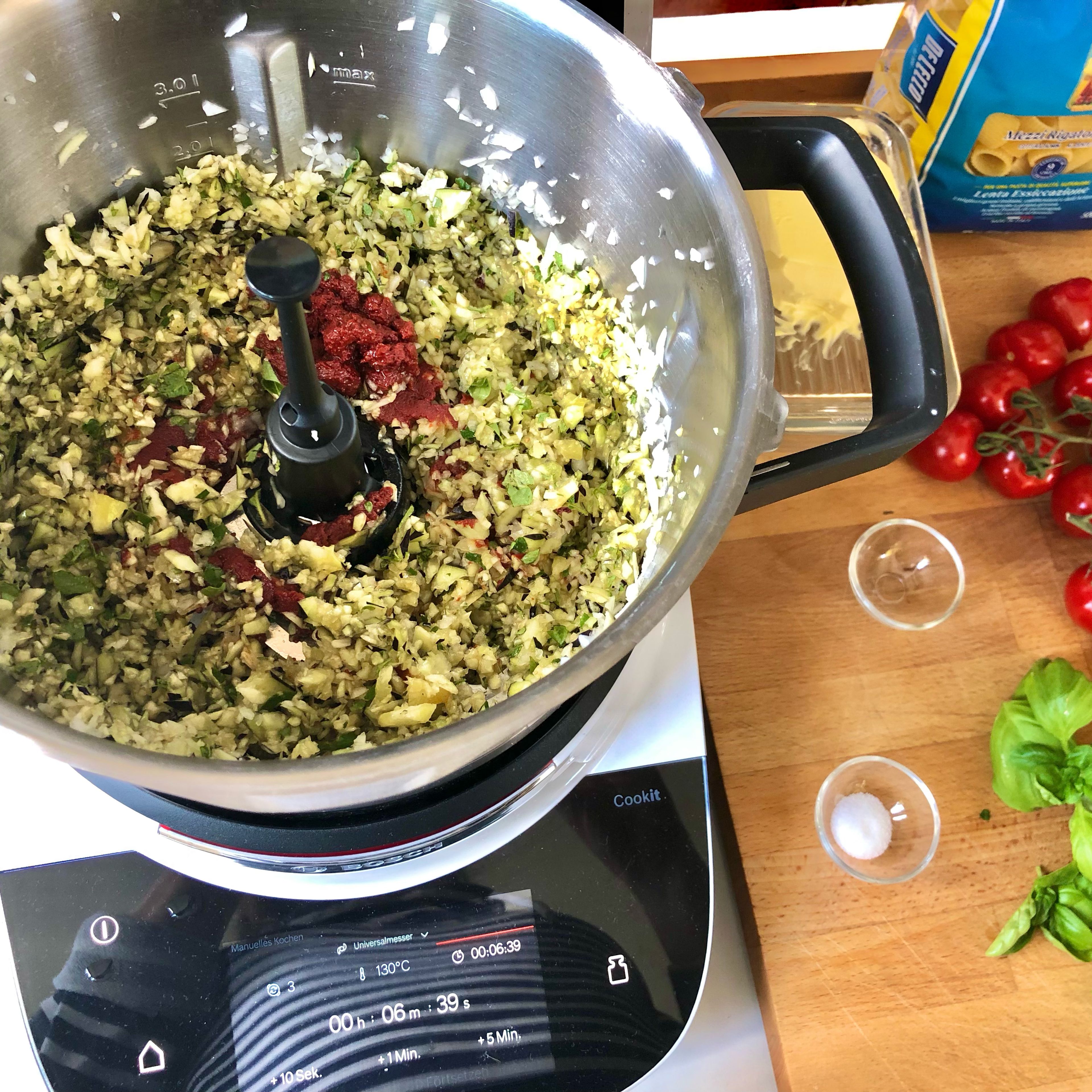80g Tomatenmark, 40 ml Olivenöl und 20 ml Wasser einwiegen, je einen gestr. Teelöffel Salz und Zucker einstreuen. Sicherstellen, dass das Gemüse nicht am Rand klebt und anbraten (Stufe 4 | 130 Grad | 4 Minuten).