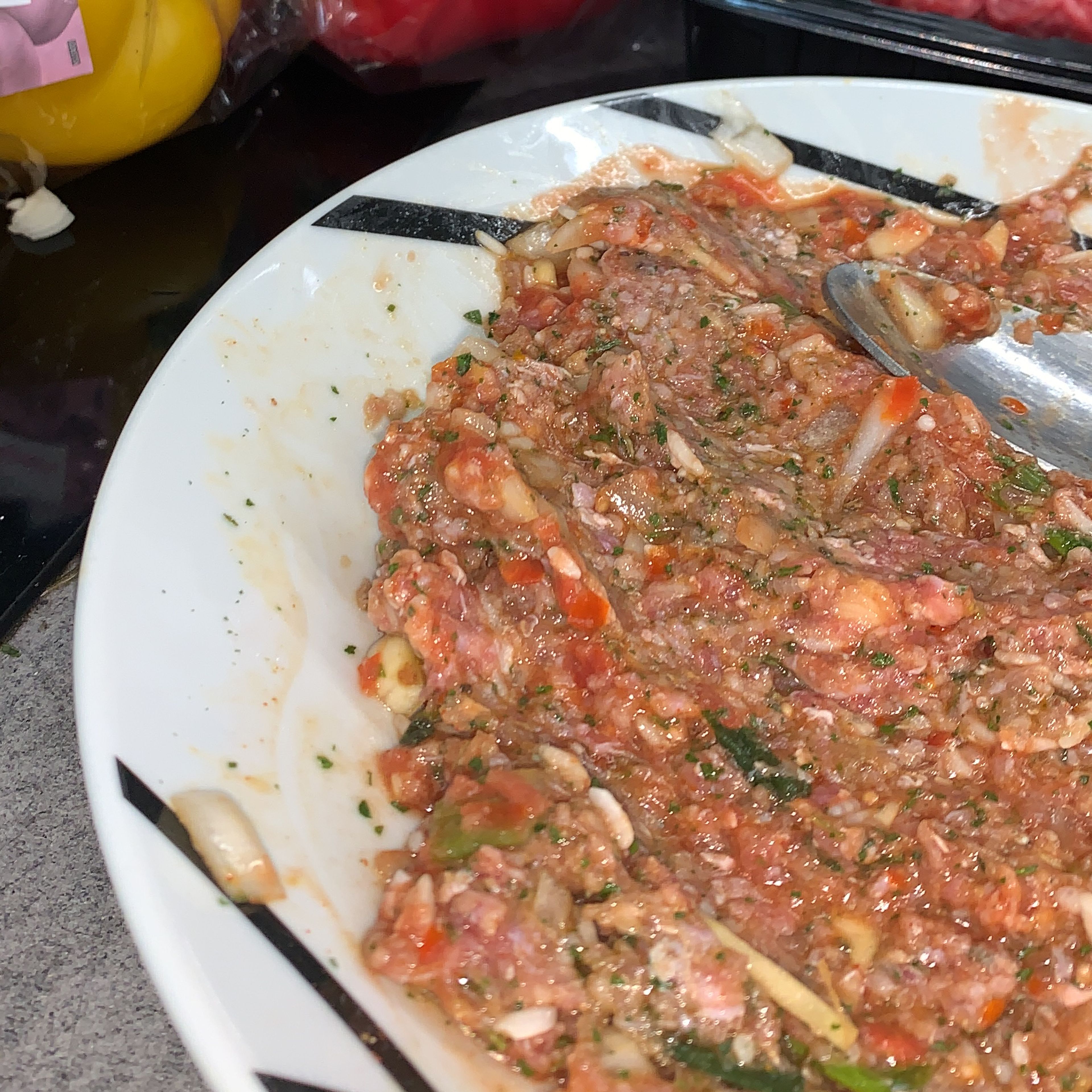 Chop your onion and garlic, wet your rice and set it aside. Blend 1 tomato , mix it with the tomato sauce and add only half of it to the minced beef. Make the rest of the filling by adding the following to the minced beef. Then mix everything until all is combined.