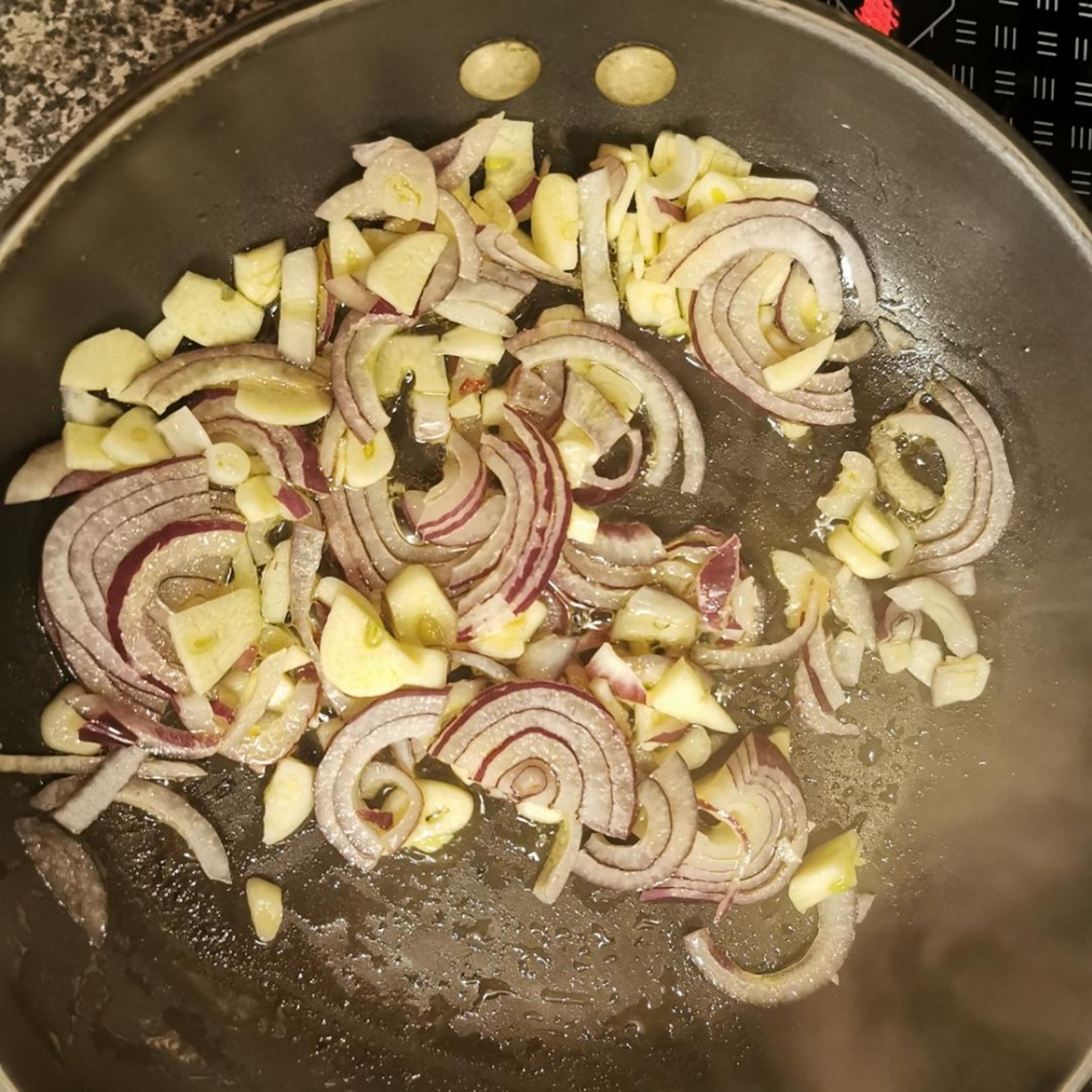 Knoblauch und Zwiebeln kleinhacken und mit etwas Öl anbraten. Ofen auf 200 Grad vorheizen.