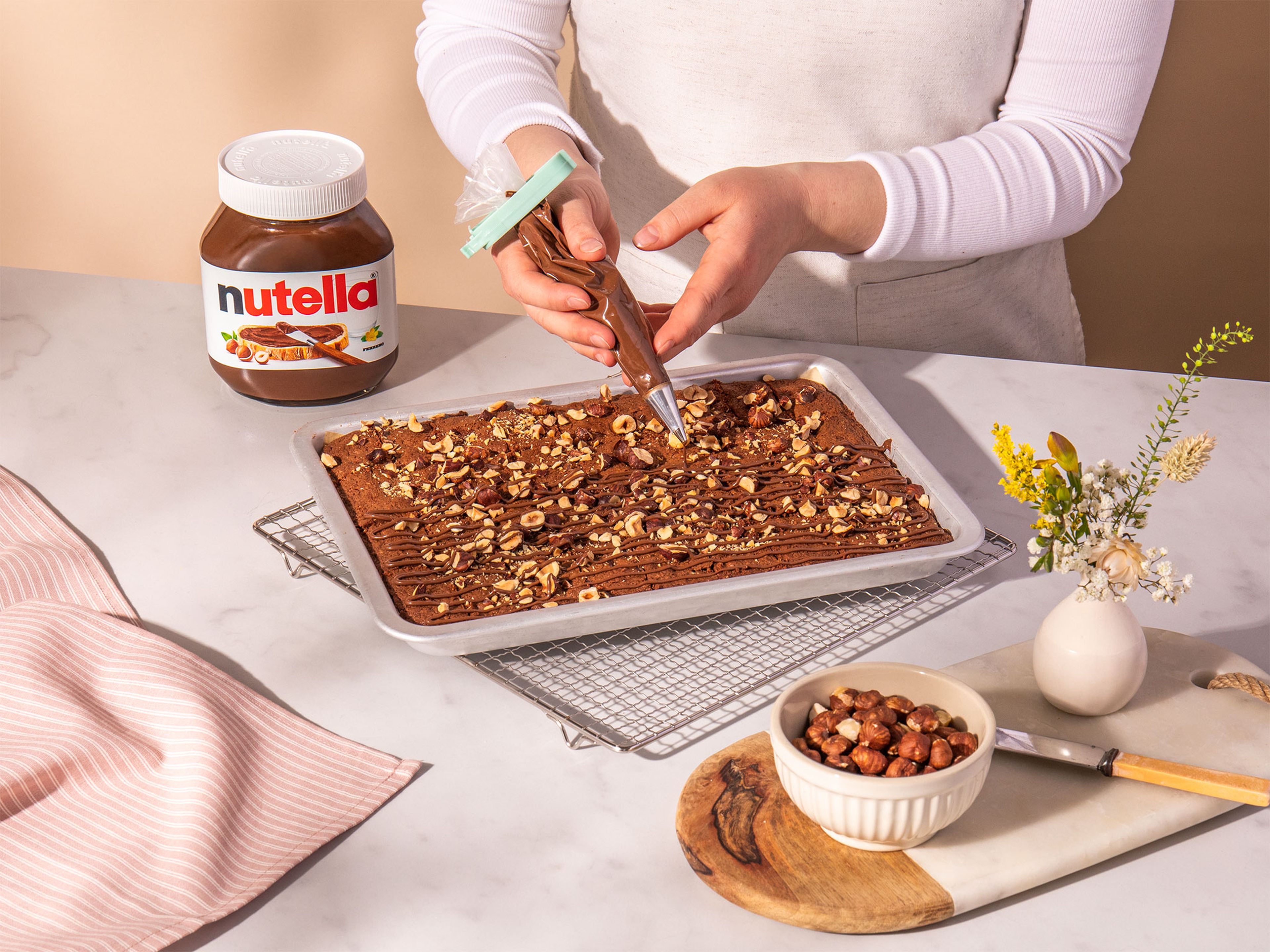 Den Brownie mit nutella® garnieren und in kleine Häppchen schneiden.