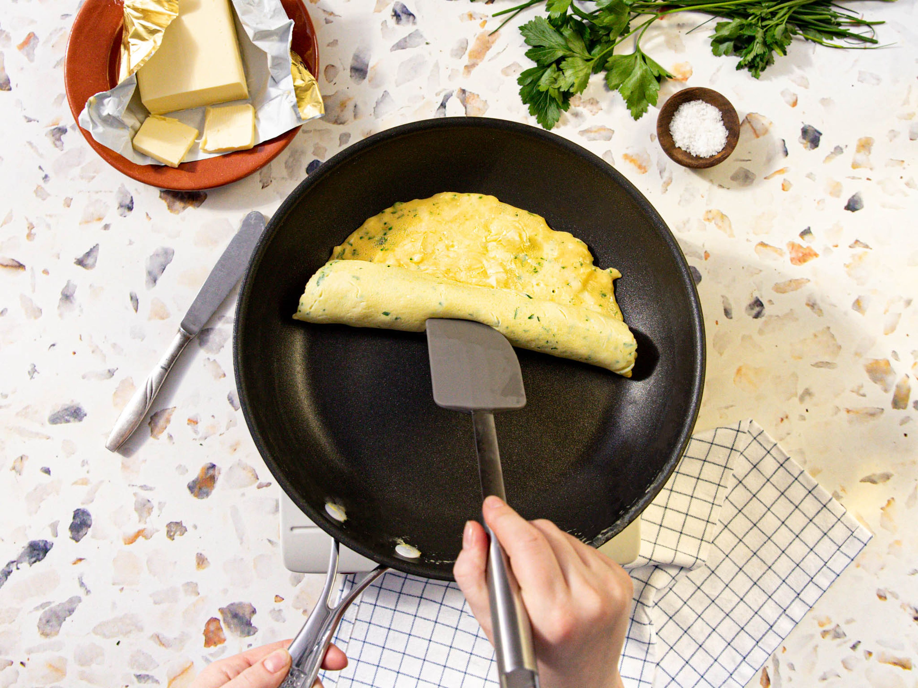 Käse über die Eier streuen. Wenn die Masse zu flüssig aussieht, ca. 20 Sek. ruhen lassen, dann den gegenüberliegenden Rand mit einem Pfannenwender anheben und leicht aufrollen. Vorsichtig auf einen Teller geben und mit den restlichen Kräutern und ggf. Butter garnieren. Guten Appetit!