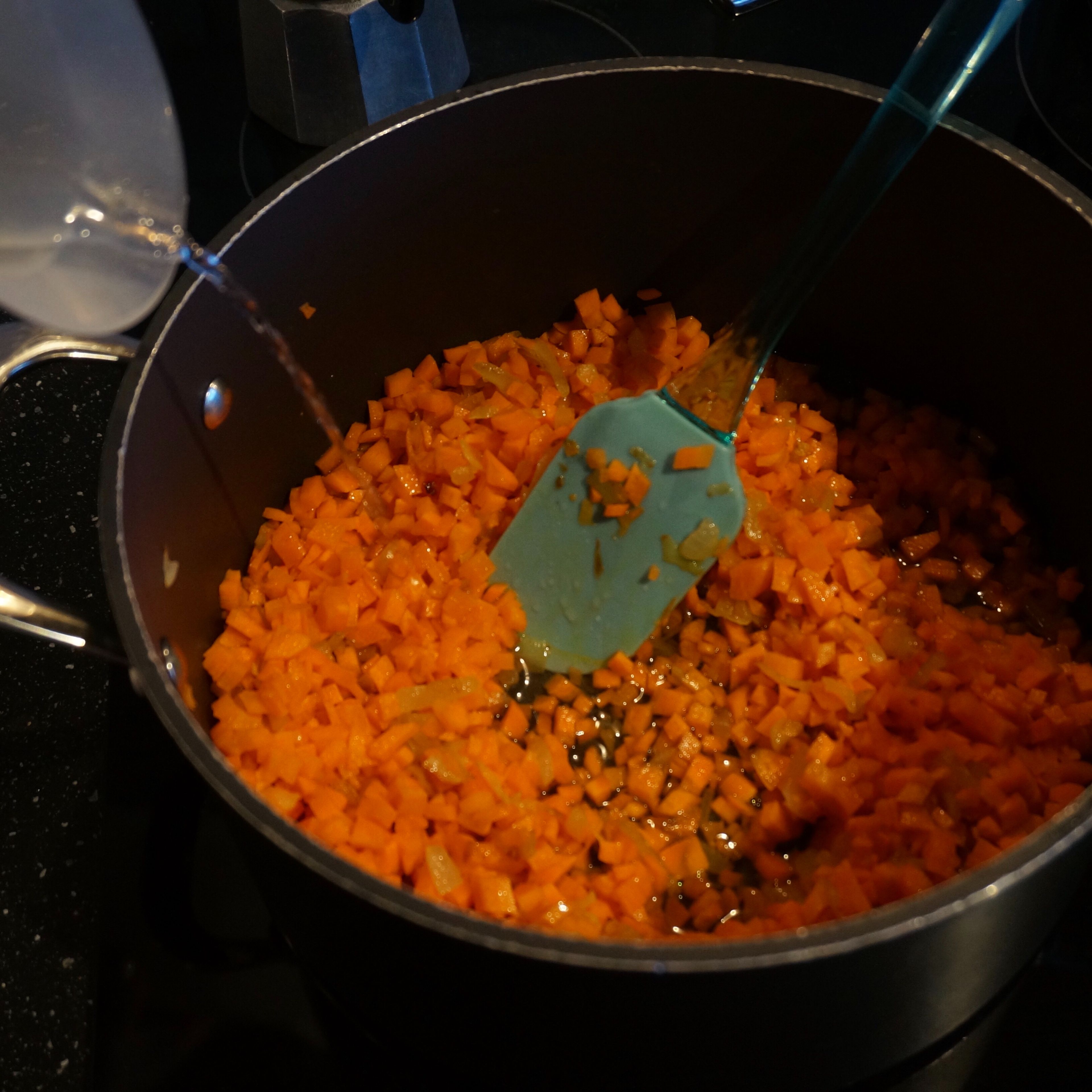 Cut the carrots into small cubes, add to the onion. Fry for 1 minute and then add water. Cover the saucepan and simmer for about 10 minutes.