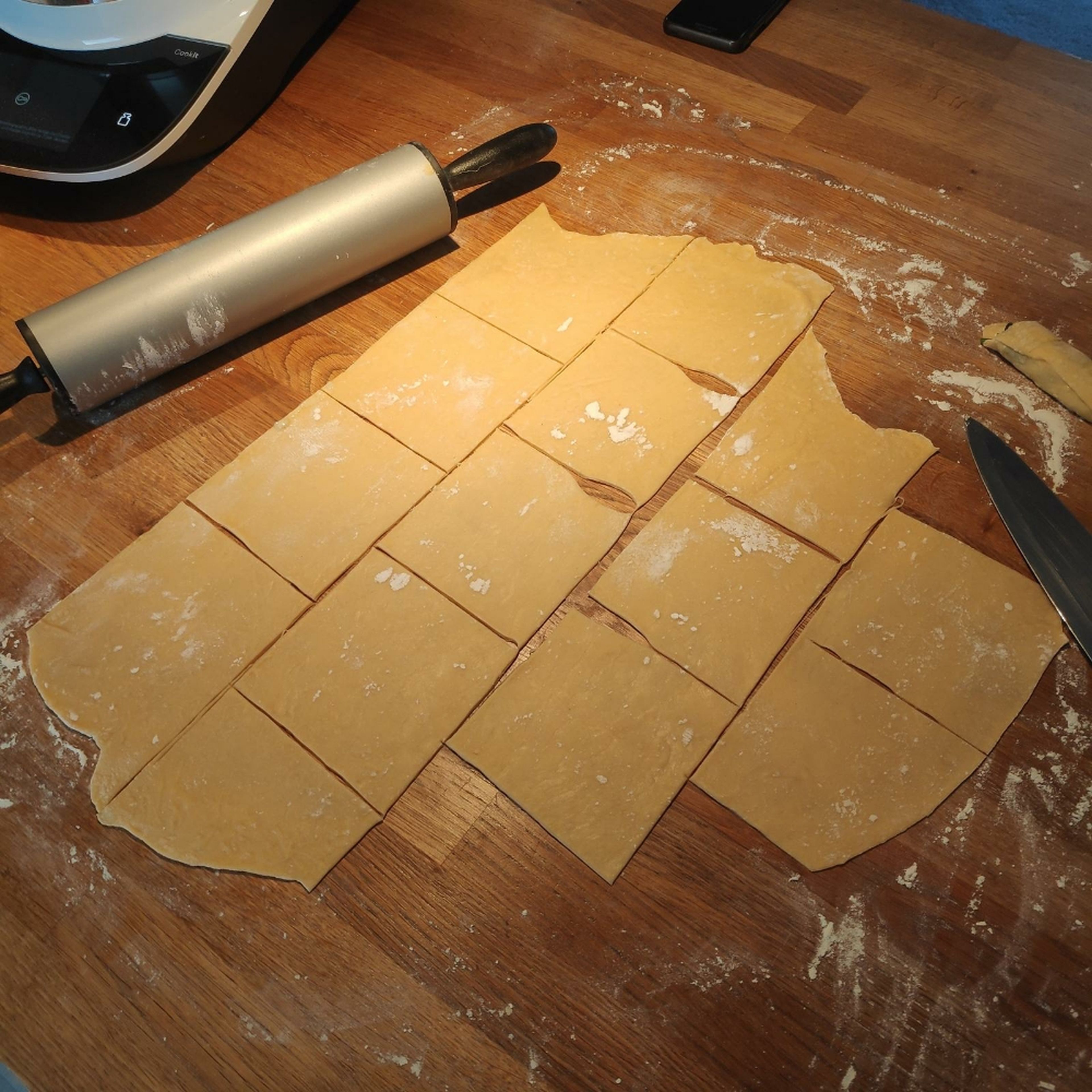 Den Nudelteig mit reichlich Mehl ausrollen und in Quadrate schneiden (ca. 10x10 cm). Die Auflaufform einbuttern und den Boden mit etwas von der Béchamelsauce bedecken.