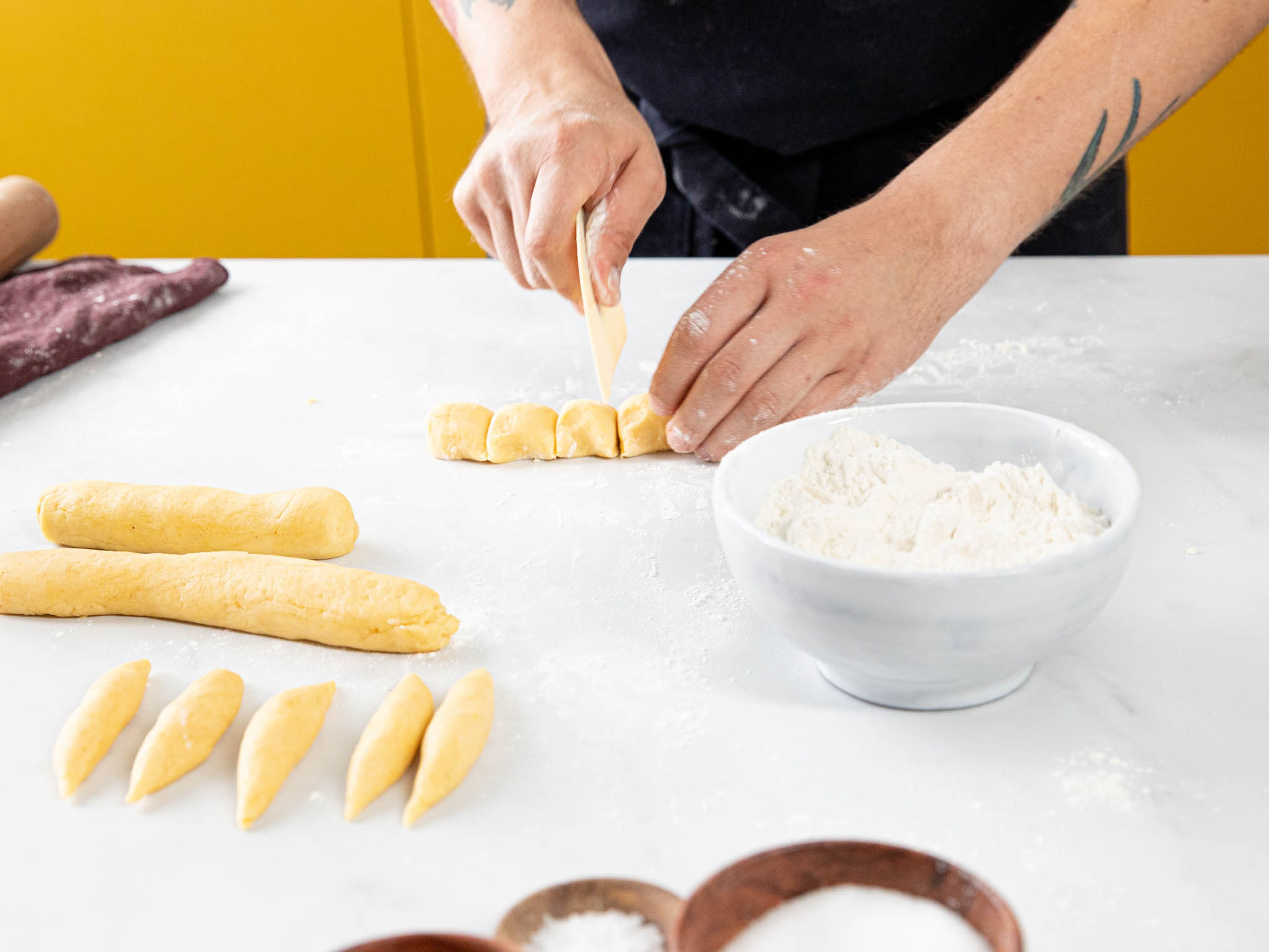 Divide the dough into 4 and roll into strips approx 4-cm./1-in. thick, then cut into evenly sized pieces, measuring approx. the same width-wise. Roll each into dumplings with pointed ends, measuring approx. 2-cm./3/4-in. wide.