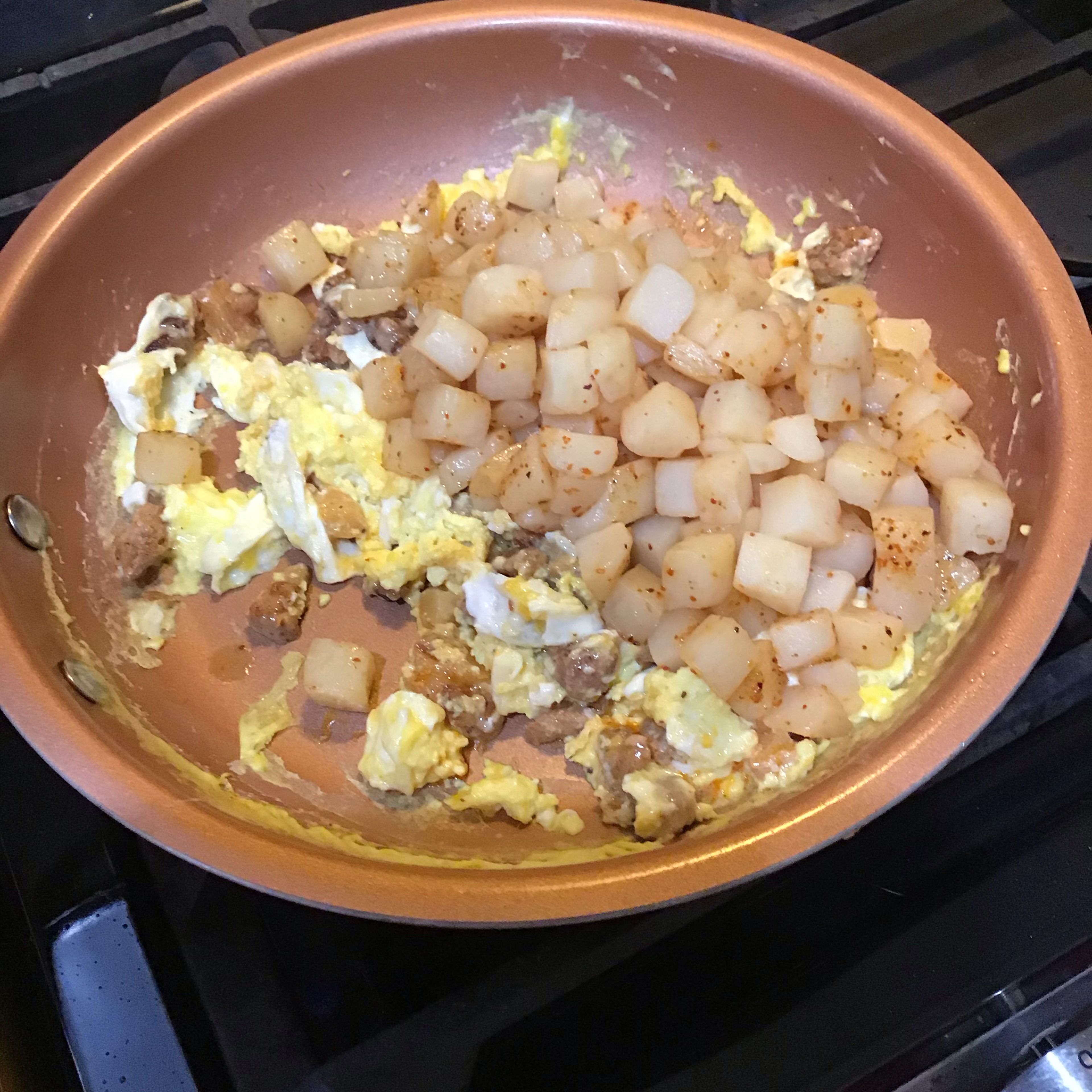 Add potatoes to larger frying pan with the eggs 