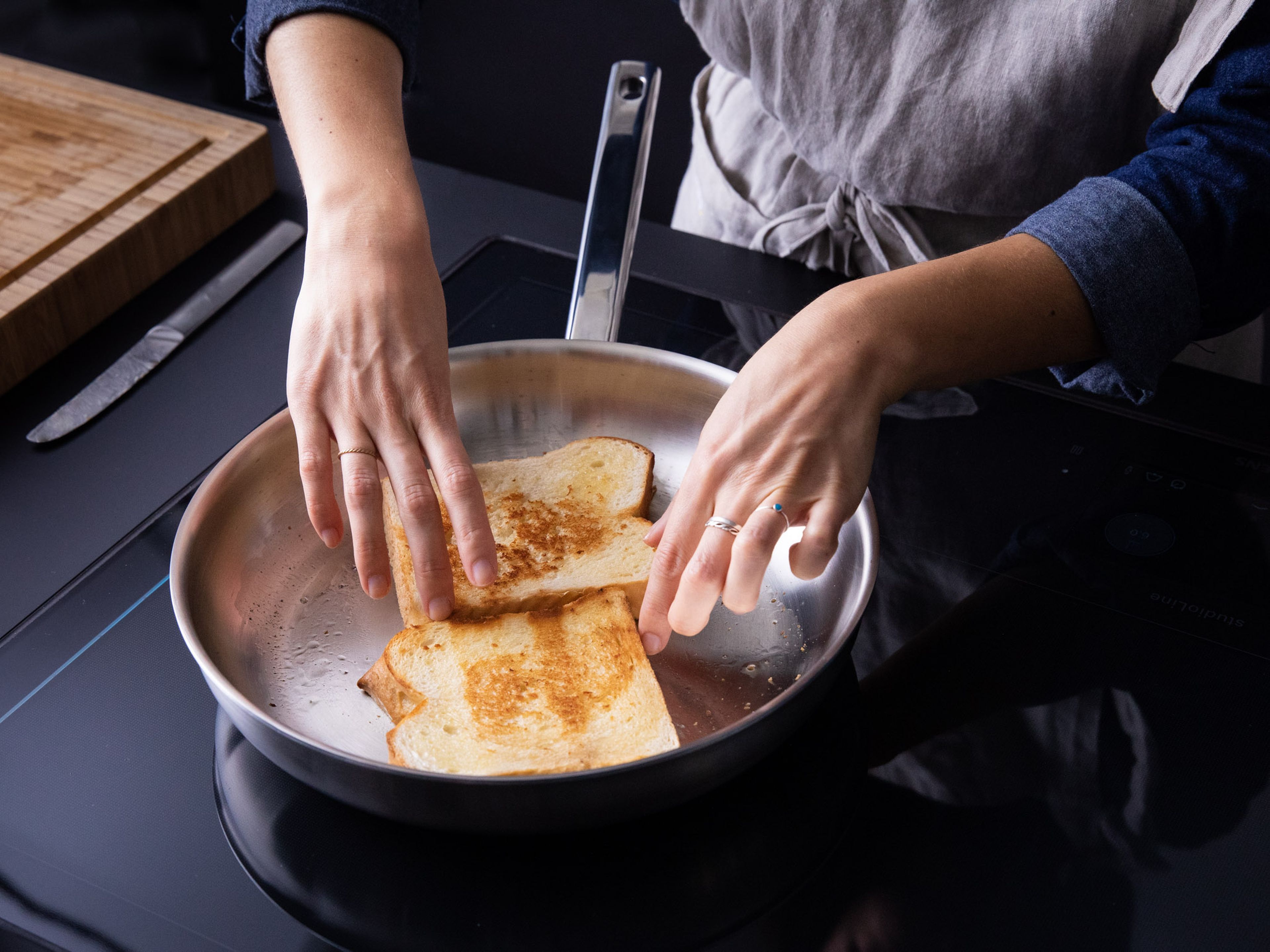 Spread butter on each side of the bread slices. In the same frying pan, toast the bread on each side until golden brown. Cut tomato into thick slices and season with sea salt and pepper.