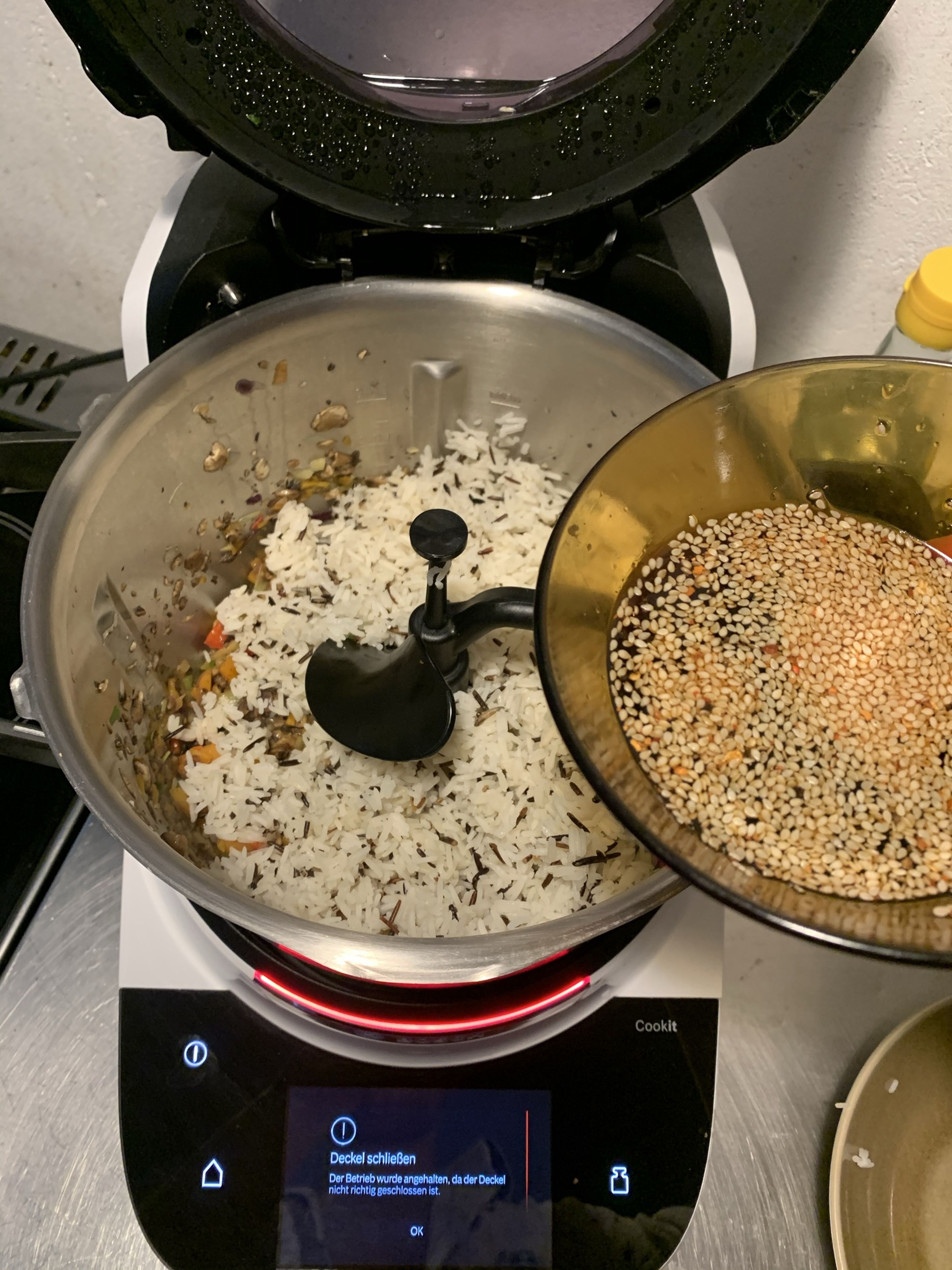 Den Reis zusammen mit der Sauce in den Cookit geben, Deckel ohne Messbecher schließen und weiter anbraten (3D-Rührer | Stufe 4 | 150°C | 4 Min.).