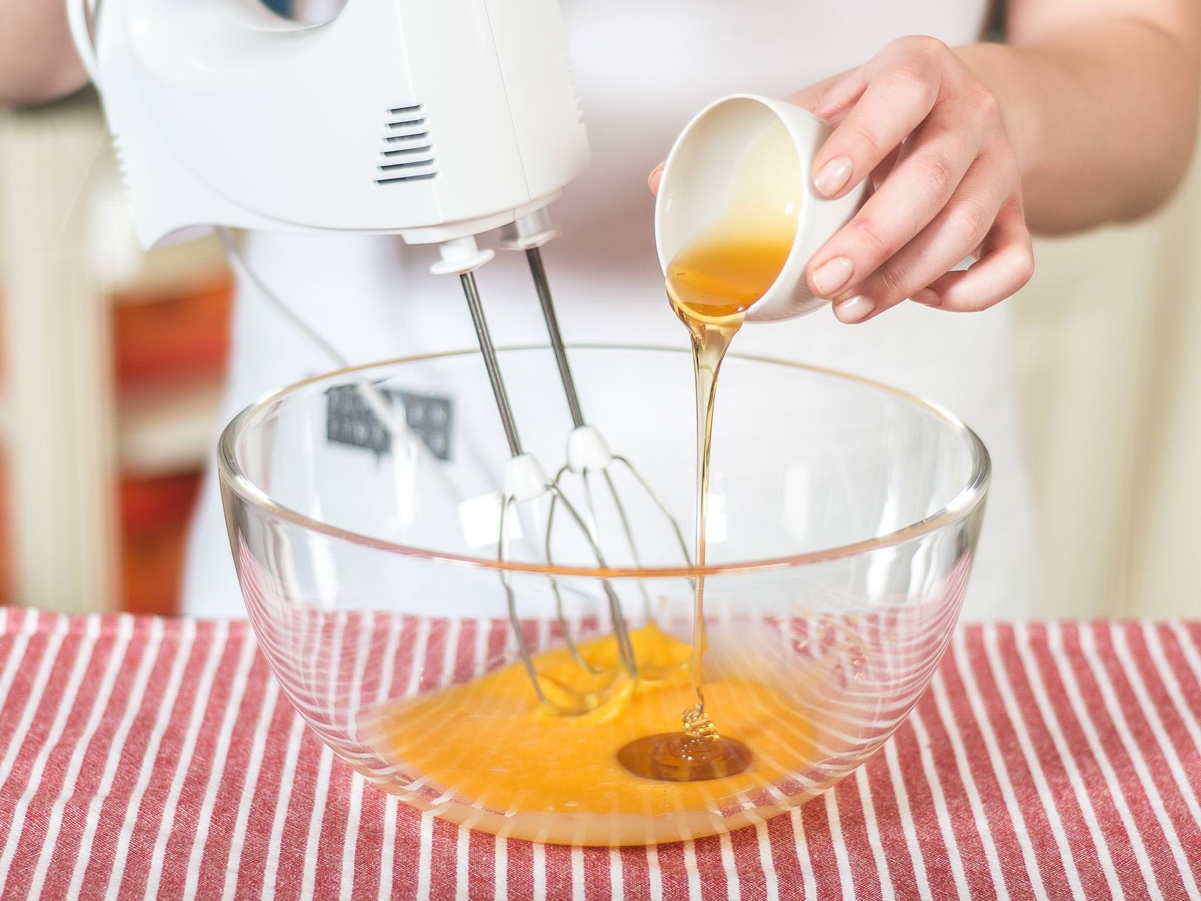 Eigelbe und Honig mit einem Handrührgerät hell schaumig aufschlagen. Grand Marnier und eine kleine Prise Salz hinzugeben und ebenso unterrühren.