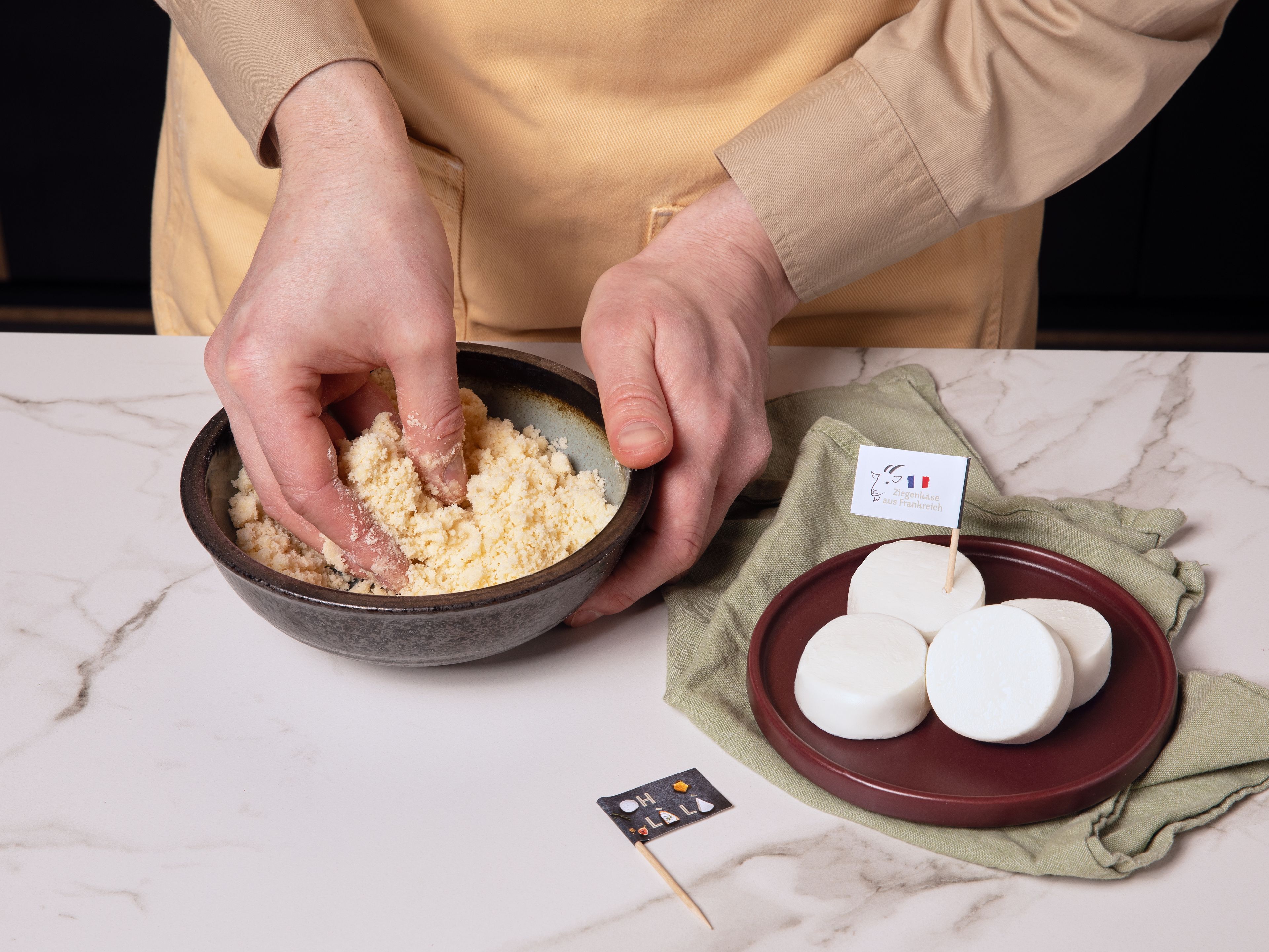 Zuerst den Backofen auf 180 °C (Ober-/Unterhitze) vorheizen. Schale der Zitrone abreiben. Für den Zitronen-Crumble Mehl, die Hälfte des Zuckers und Zitronenschale in einer Schüssel vermengen. Die kalte Butter in kleinen Stücken dazugeben und mit den Fingern zu Streuseln verarbeiten. Diese auf ein mit Backpapier belegtes Blech geben und ca. 12–15 Min. goldbraun backen. Danach vollständig auskühlen lassen. Währenddessen mit dem Rezept fortfahren.