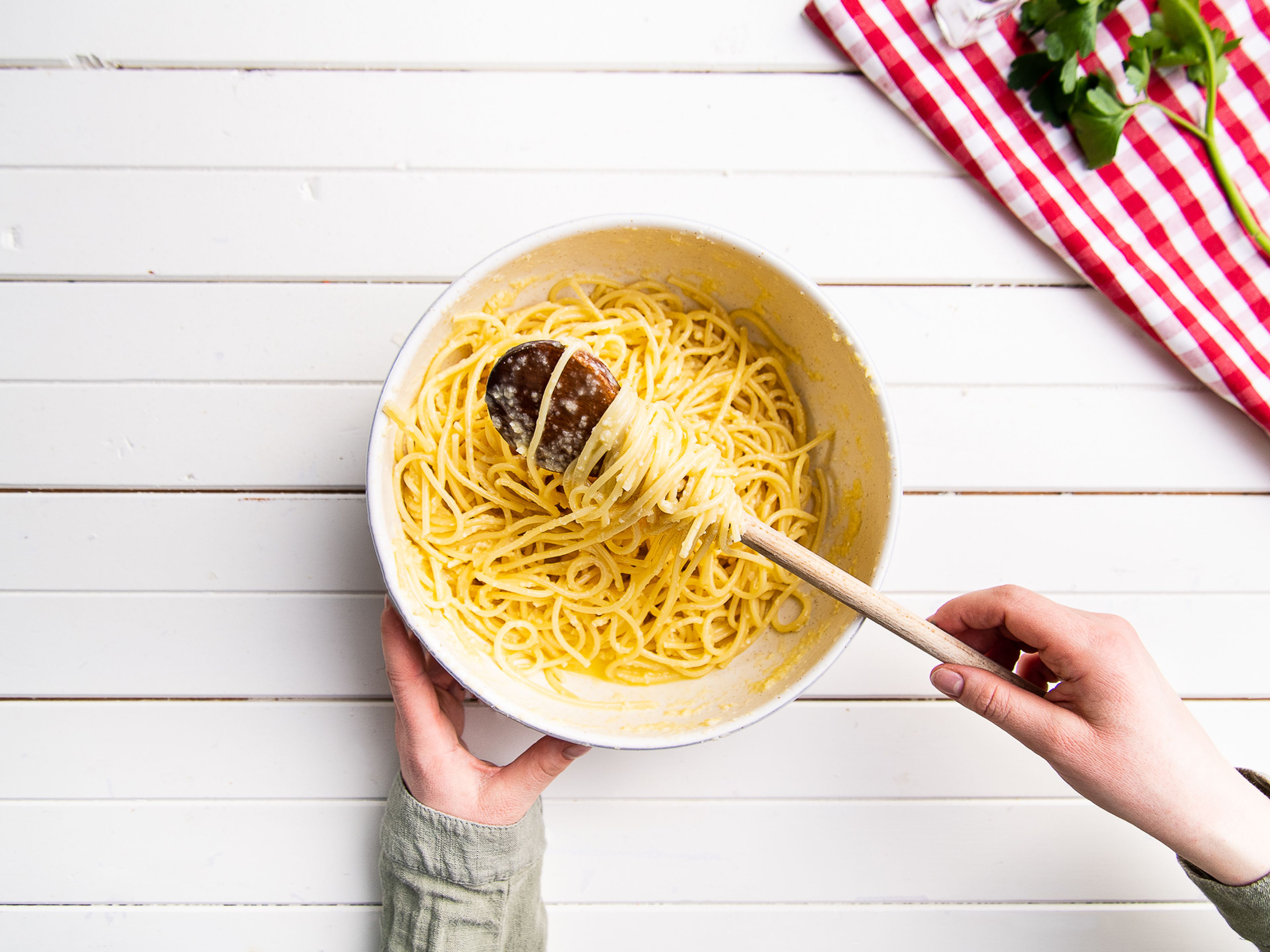 Den Ofen auf 180°C vorheizen. Spaghetti in kochendem Salzwasser ca. 10 Min. al dente kochen und abgießen. Eier in eine Schüssel geben, etwas von dem geriebenen Parmesan hinzufügen und miteinander verquirlen. Spaghetti hinzufügen und mit der Parmesan-Ei-Mischung vermengen.