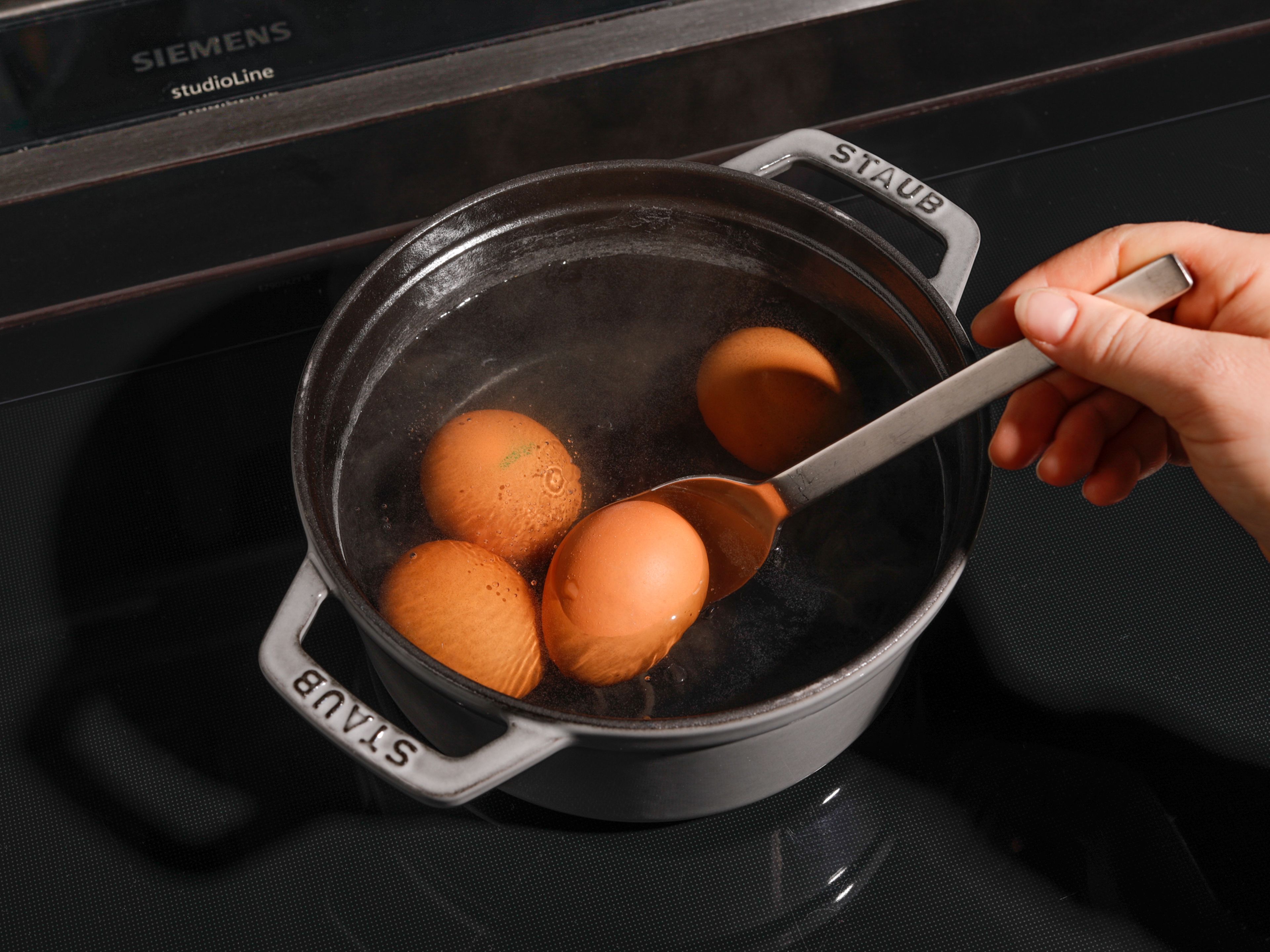 Bring a pot of water to boil, gently lower eggs in with a spoon, and cook for approx. 6 min. and 30. sec. Remove and transfer to a bowl of ice water to cool.