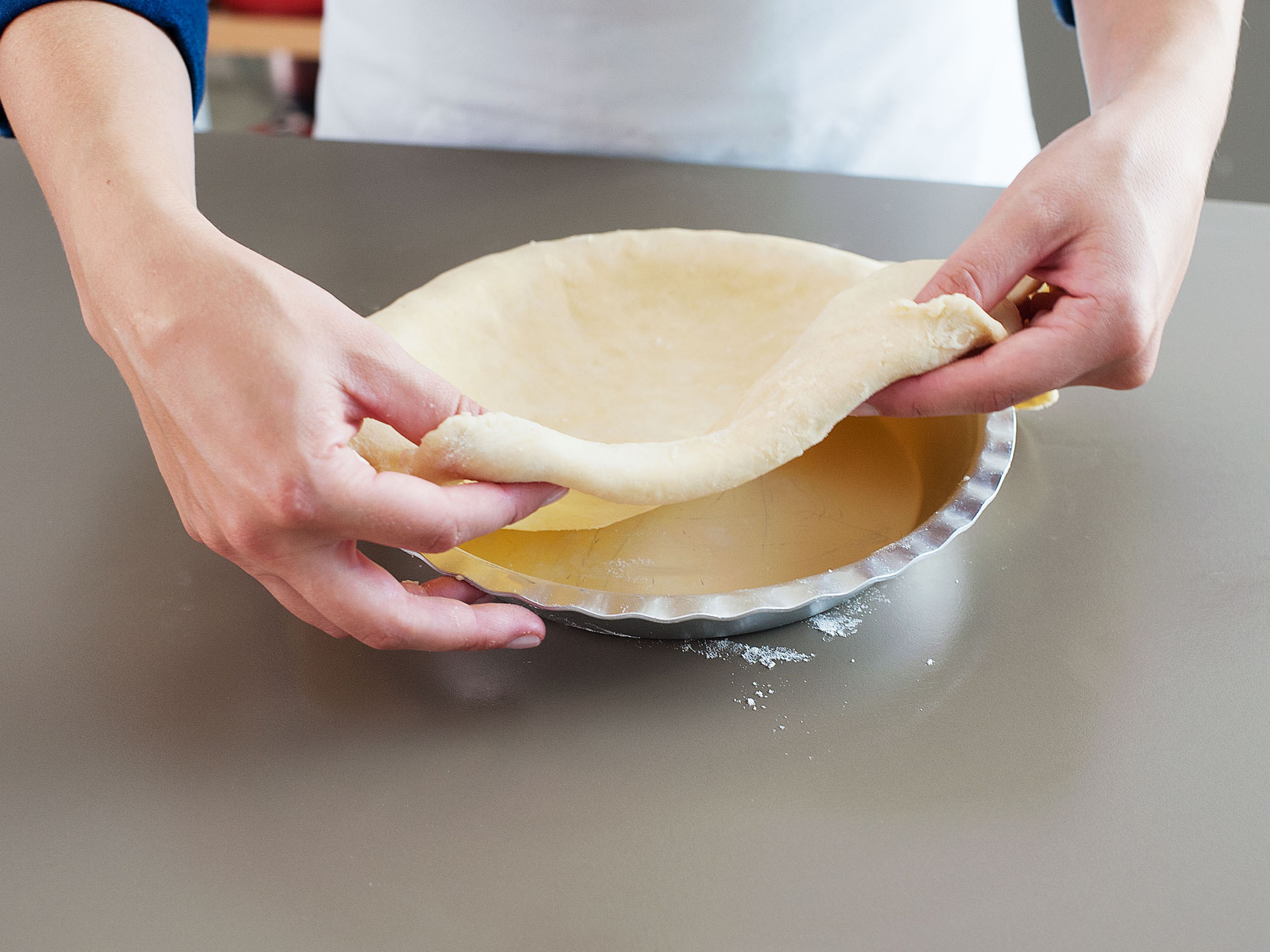 Backofen auf 190°C vorheizen. Pie-Form einfetten. Den Teig aus dem Kühlschrank nehmen und einige Minuten bei Zimmertemperatur aufwärmen. Arbeitsfläche leicht bemehlen und eine Teighälfte zu einem Kreis ausrollen, der ca. 0.5 cm dick ist. Den ausgerollten Teig vorsichtig in die Pie-Form legen, dabei den überstehenden Teig über den Rand der Form hängen lassen. Sauerkirschfüllung auf den Pie-Teig gießen.