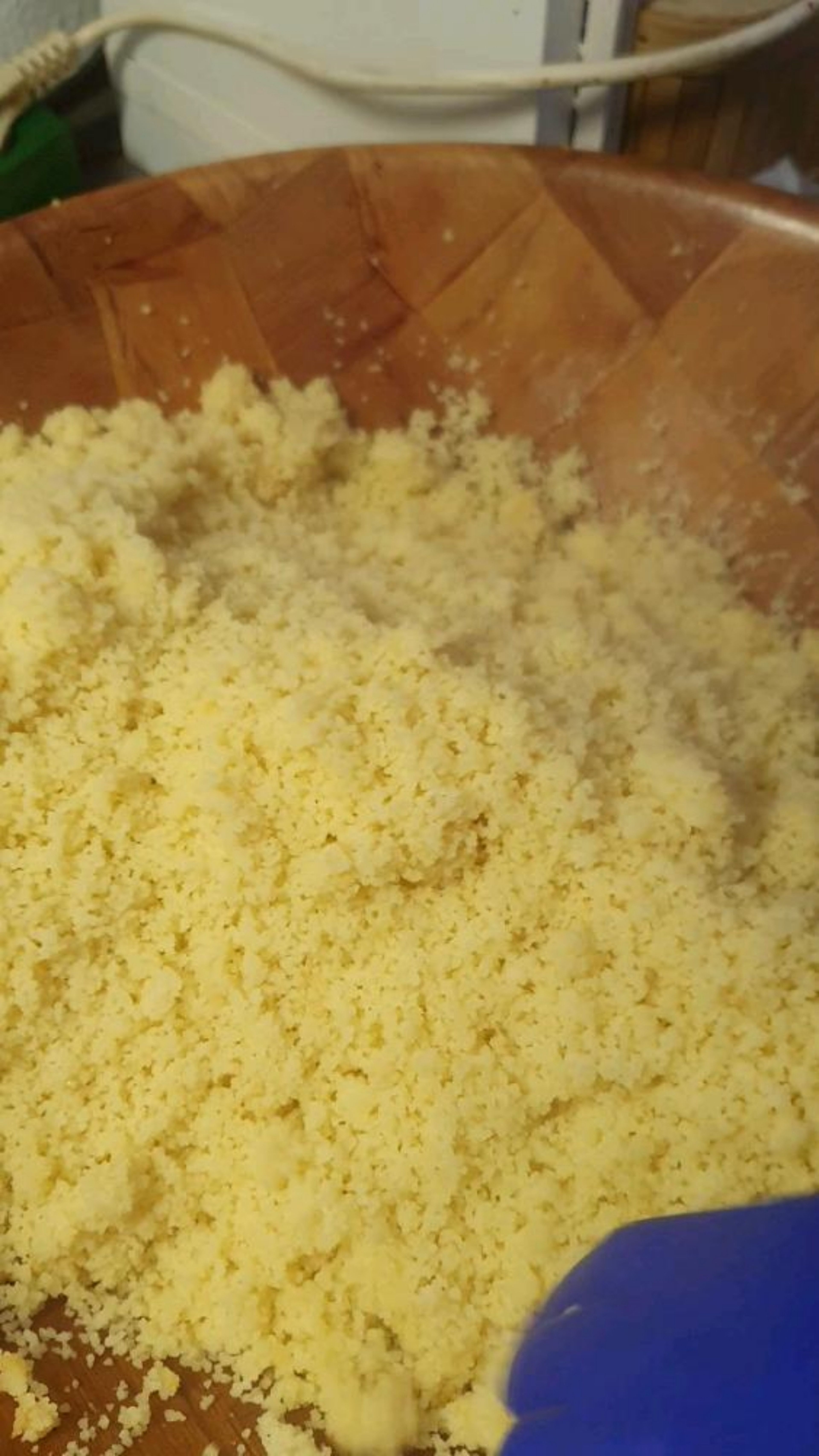 Nach Ablauf der Zeit Couscous in die große Schüssel geben, Salz und Olivenöl vorichtig drauf verteilen und mit ca. 200 ml kaltem Wasser besprenkeln, dabei den Couscous vorsichtig zwischen den Händen reiben und Verklumpungen lösen.