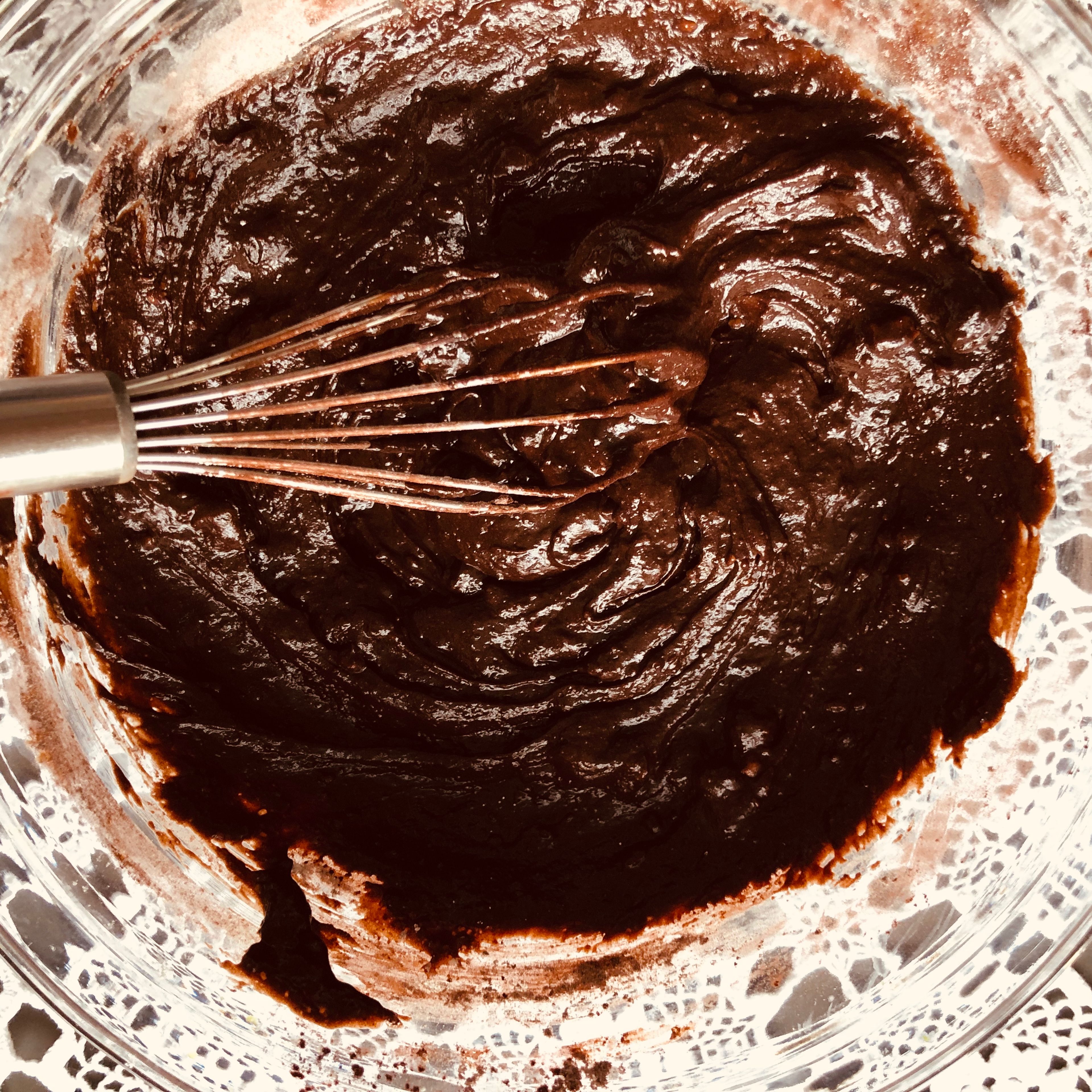 Sift the spilt flour and cocoa powder into the bowl and fold in with a spatula. Add the remaining chocolate chips and fold to incorporate .
