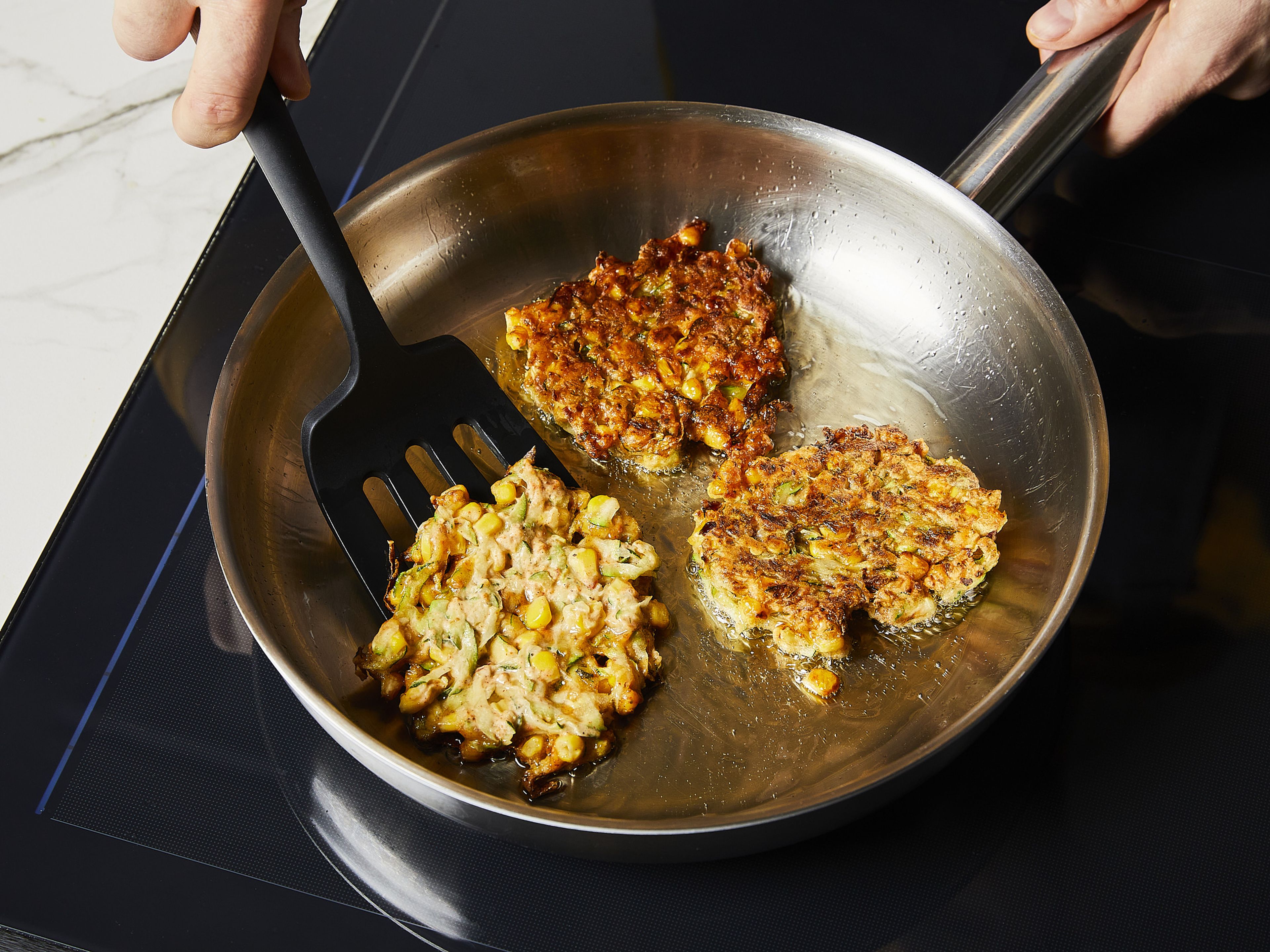 Heat the oil in a frying pan over medium-high heat. Spoon in approx. 1 tbsp of the batter and flatten slightly. Fry for approx. 4–6 min. then flip and fry the other side until golden brown and the edges are nice and crispy. Serve immediately and enjoy with the dip.