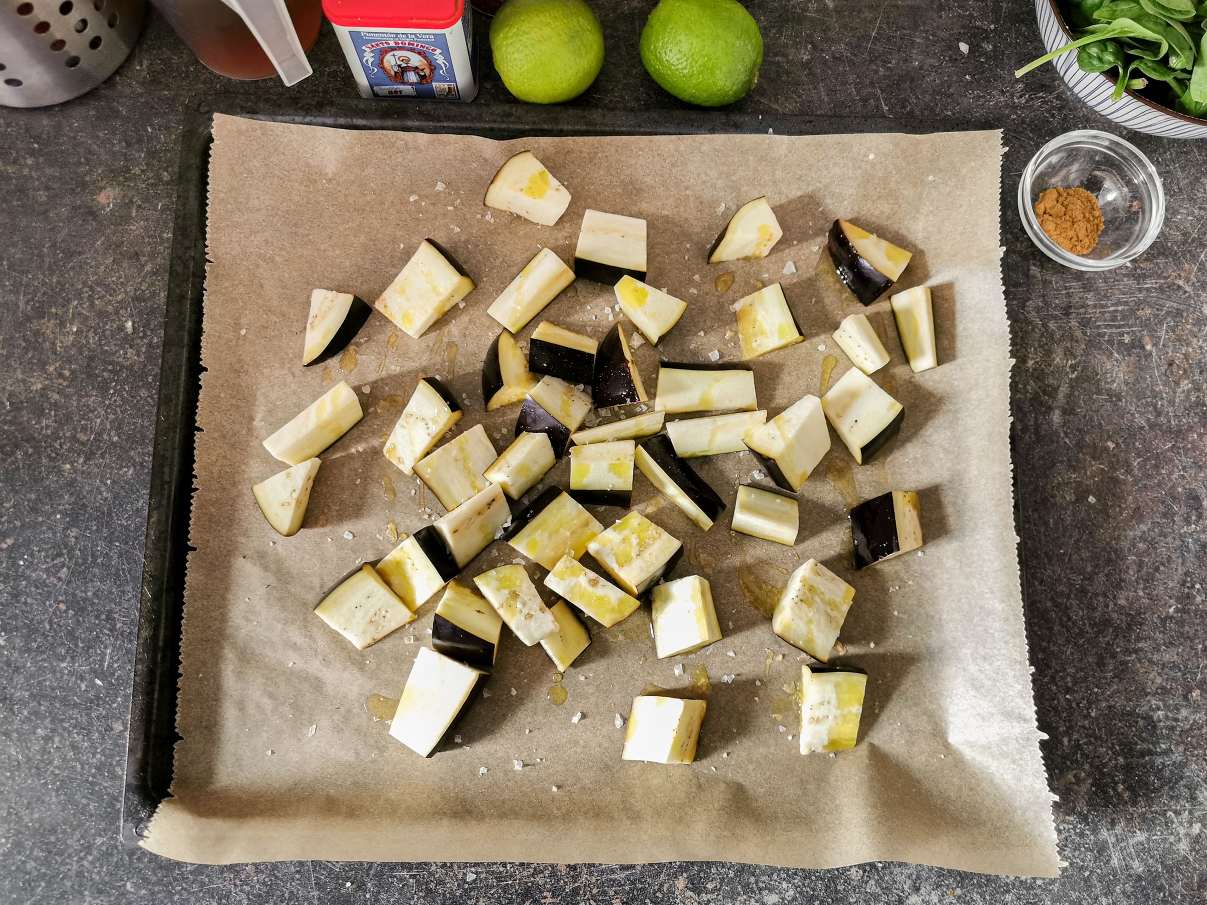 Auberginenwürfel auf ein Backblech geben. Mit Olivenöl beträufeln und mit Salz und Pfeffer würzen. Ca. 15 Min. bei 180°C backen.