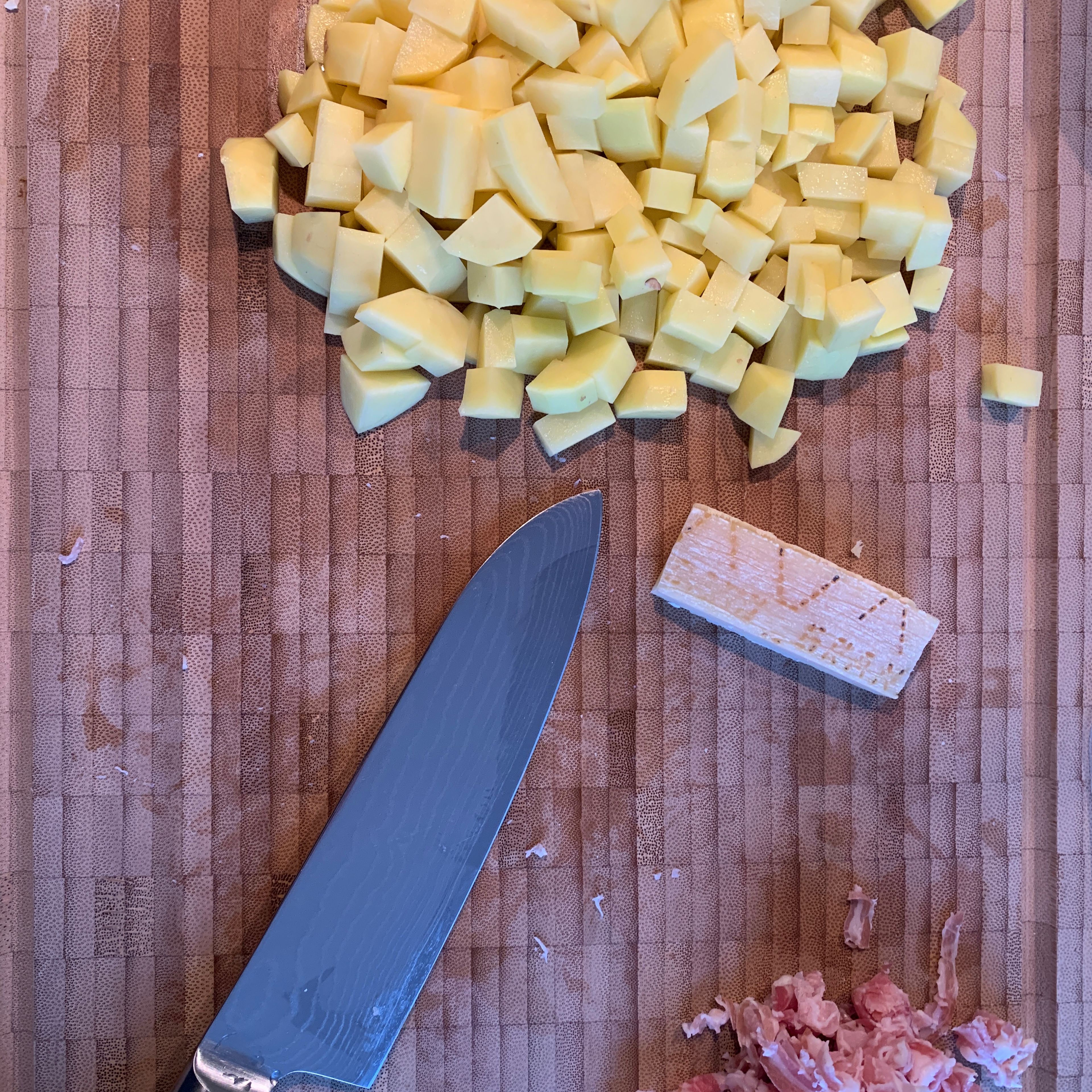 Pancetta, Zwiebel, Sellerie, Karotte in kleine Würfel schneiden. Kartoffeln schälen und auch in kleine Würfel schneiden. 