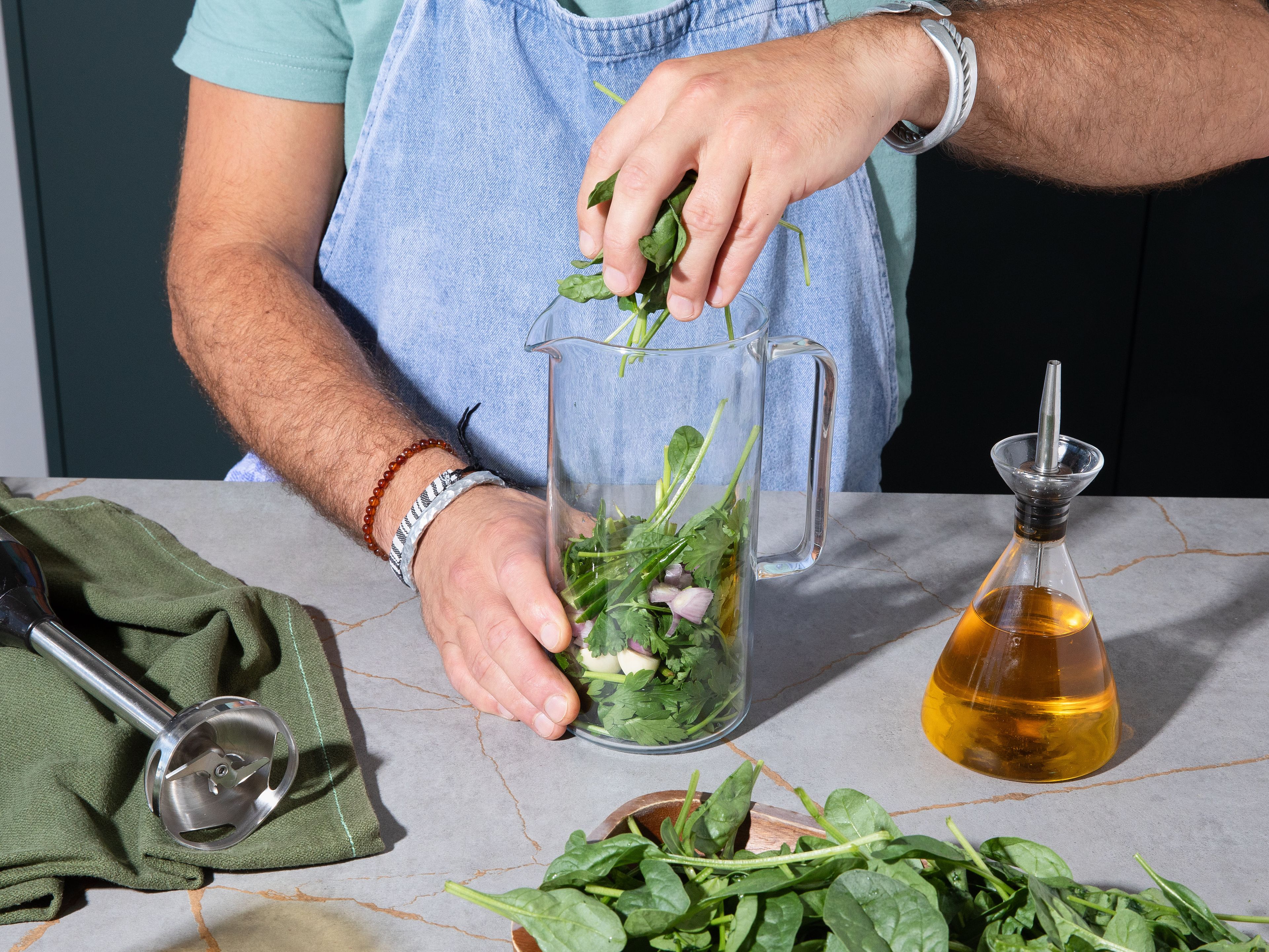 For chimichurri, halve green chili and deseed. Halve, peel and roughly chop shallot. Peel and halve garlic. Add green chili, shallot, garlic, parsley, cilantro, red wine vinegar, and olive oil to a high container and blend until roughly smooth. Then, add spinach bit by bit and blend to incorporate. Blend in more oil to your desired consistency and season with more vinegar and salt to taste. Serve salmon, cauliflower and chickpeas on chimichurri. Garnish with pomegranate seeds.