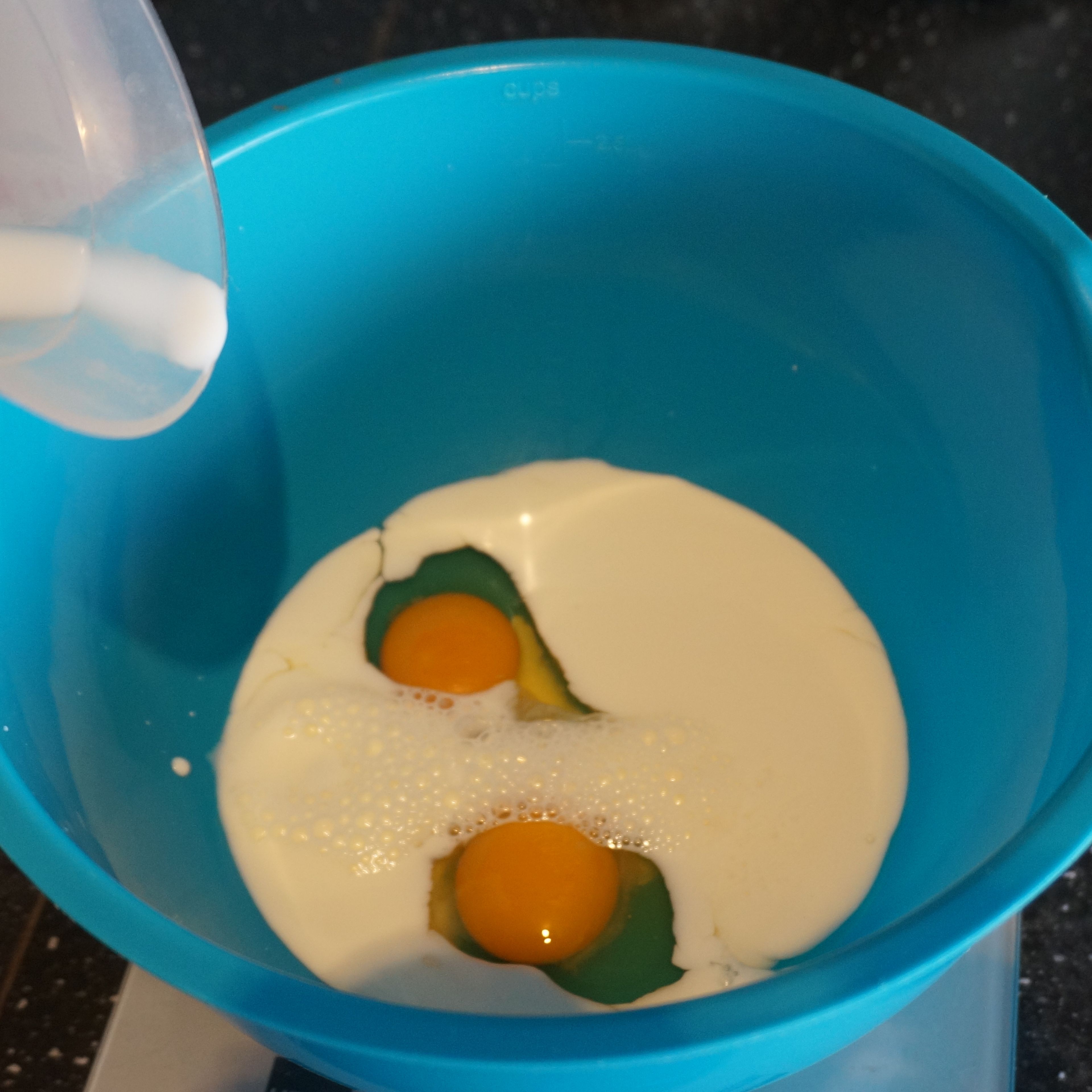 Put milk, a pinch of salt, sugar into a large bowl, crack 2 eggs and mix well.