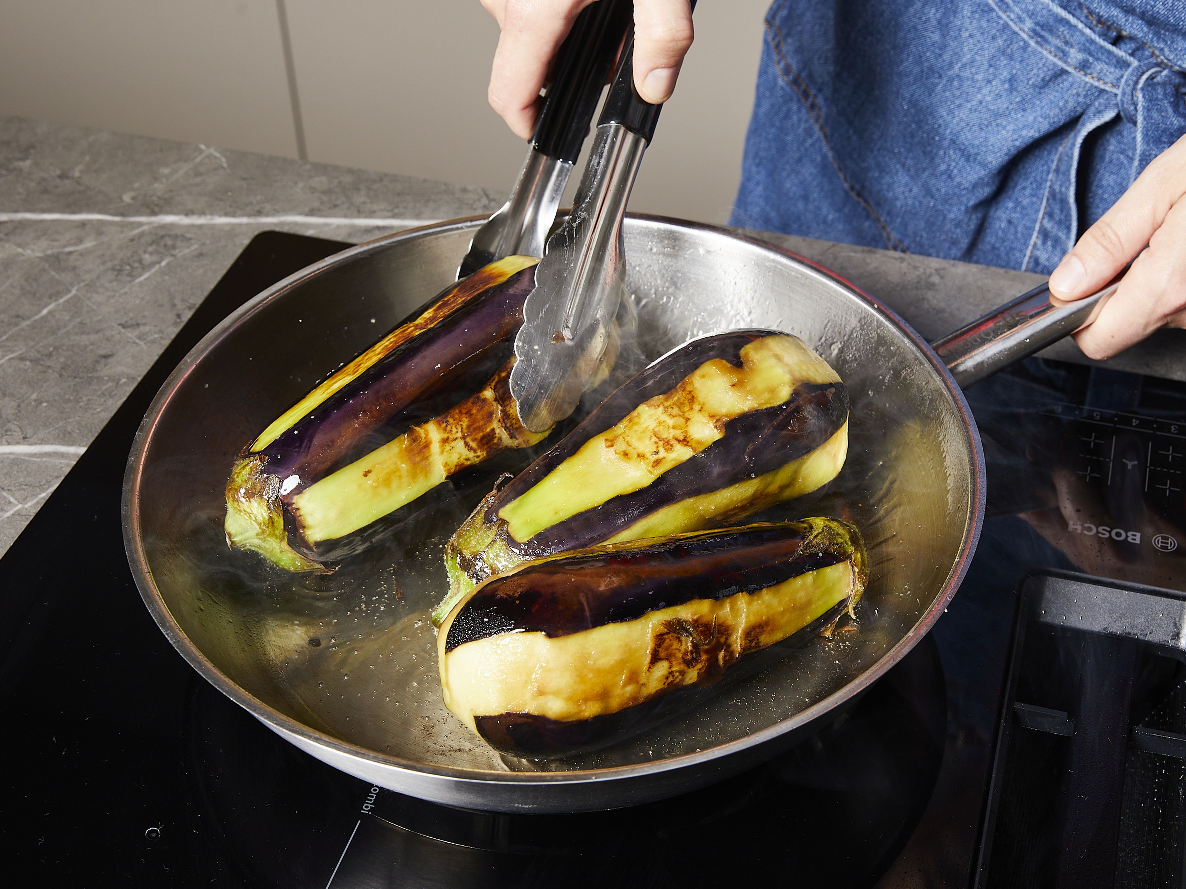 Wipe the salt off the eggplants. Heat half of the olive oil in a pan and fry the eggplants, turning regularly, until soft. Alternatively, roast the eggplants in a preheated oven at 200°C/392°F for approx. 15 mins.