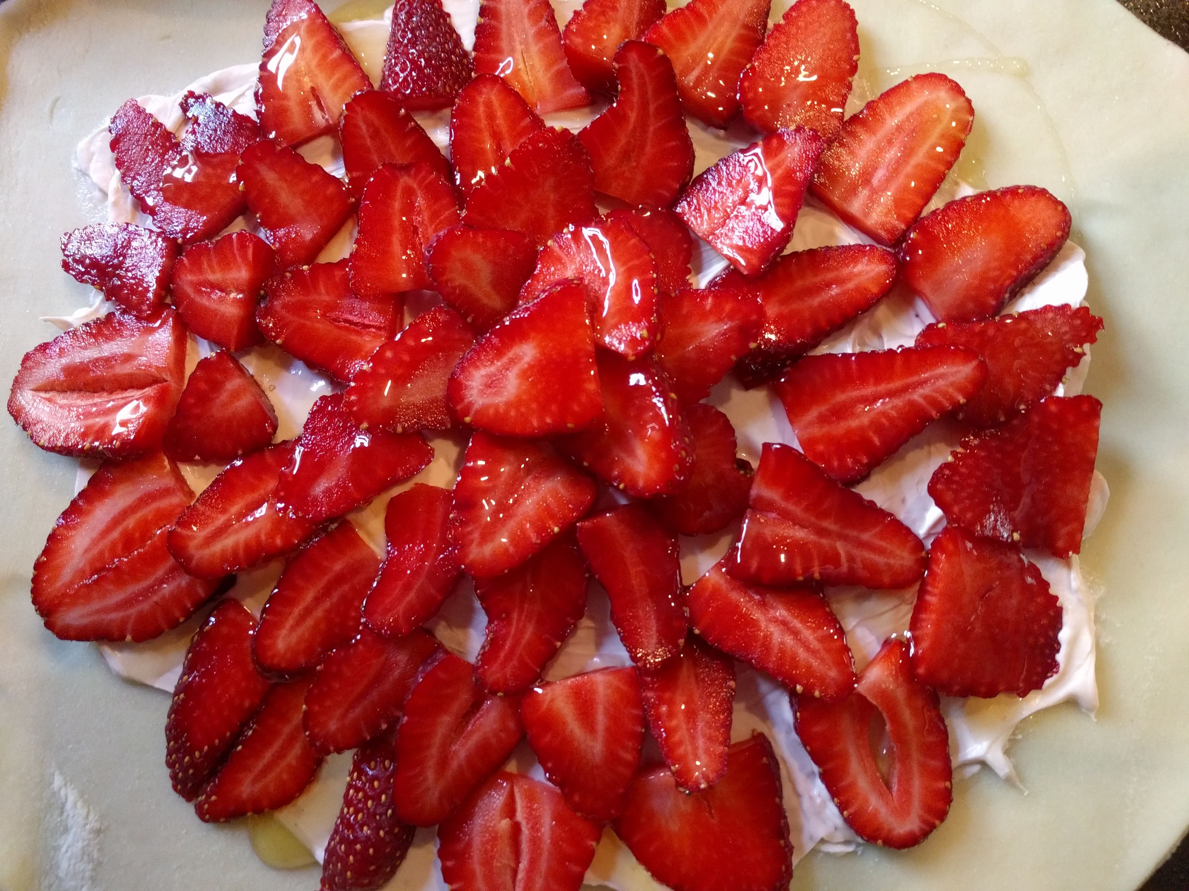 Spray nonstick cooking spray on a baking sheet. Spread pie crust across the baking sheet. Spread a thin layer of strawberry cream cheese onto the crust. Slice and arrange strawberries in any pattern you wish.