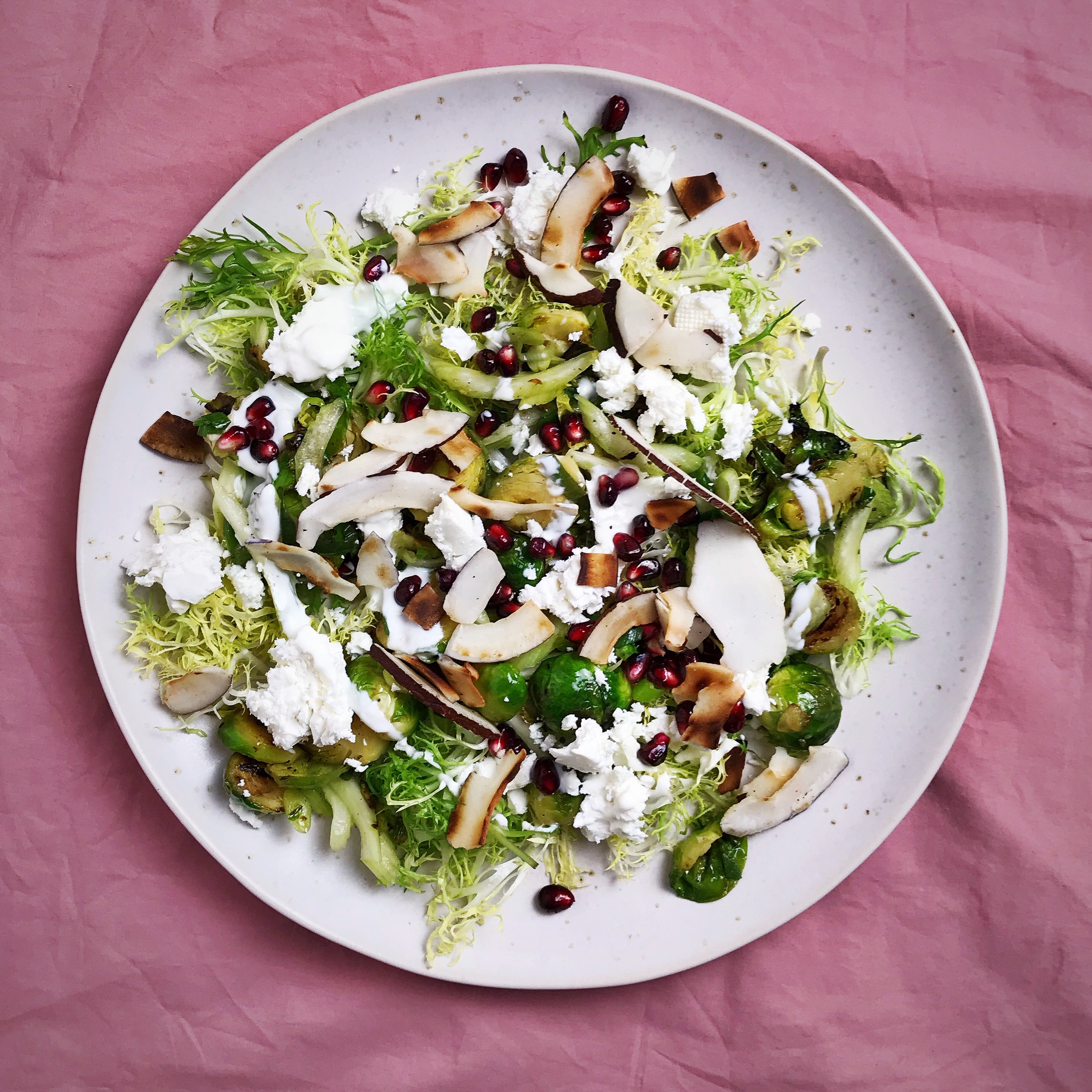 Frisée salad with Brussels sprouts, coconut, and pomegranate