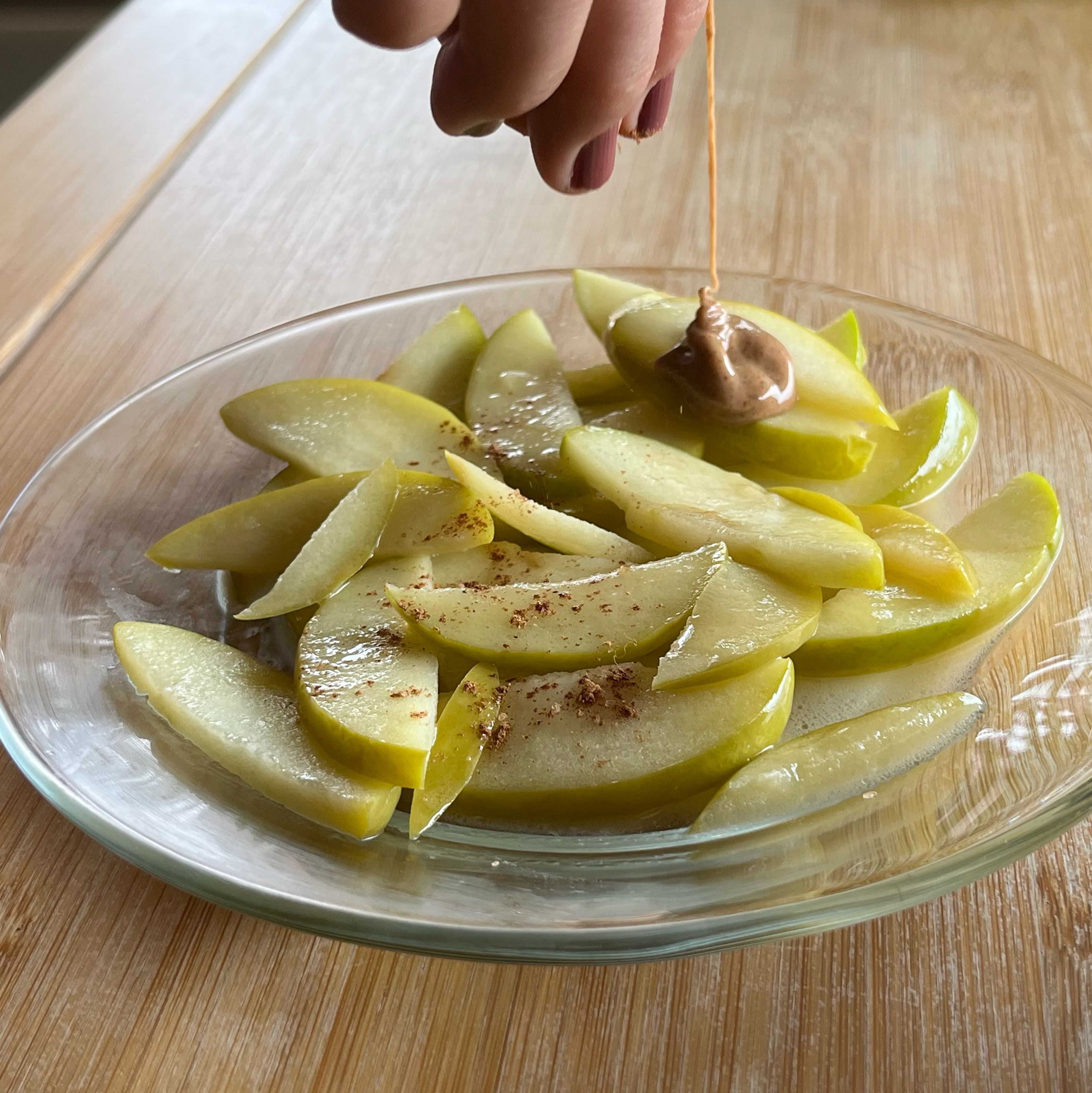 Once your apple slices are cooked, place them on a bowl or plate and drizzle (or pour 😉) almond butter, cardamom, cinnamon, and salt on top. Enjoy!