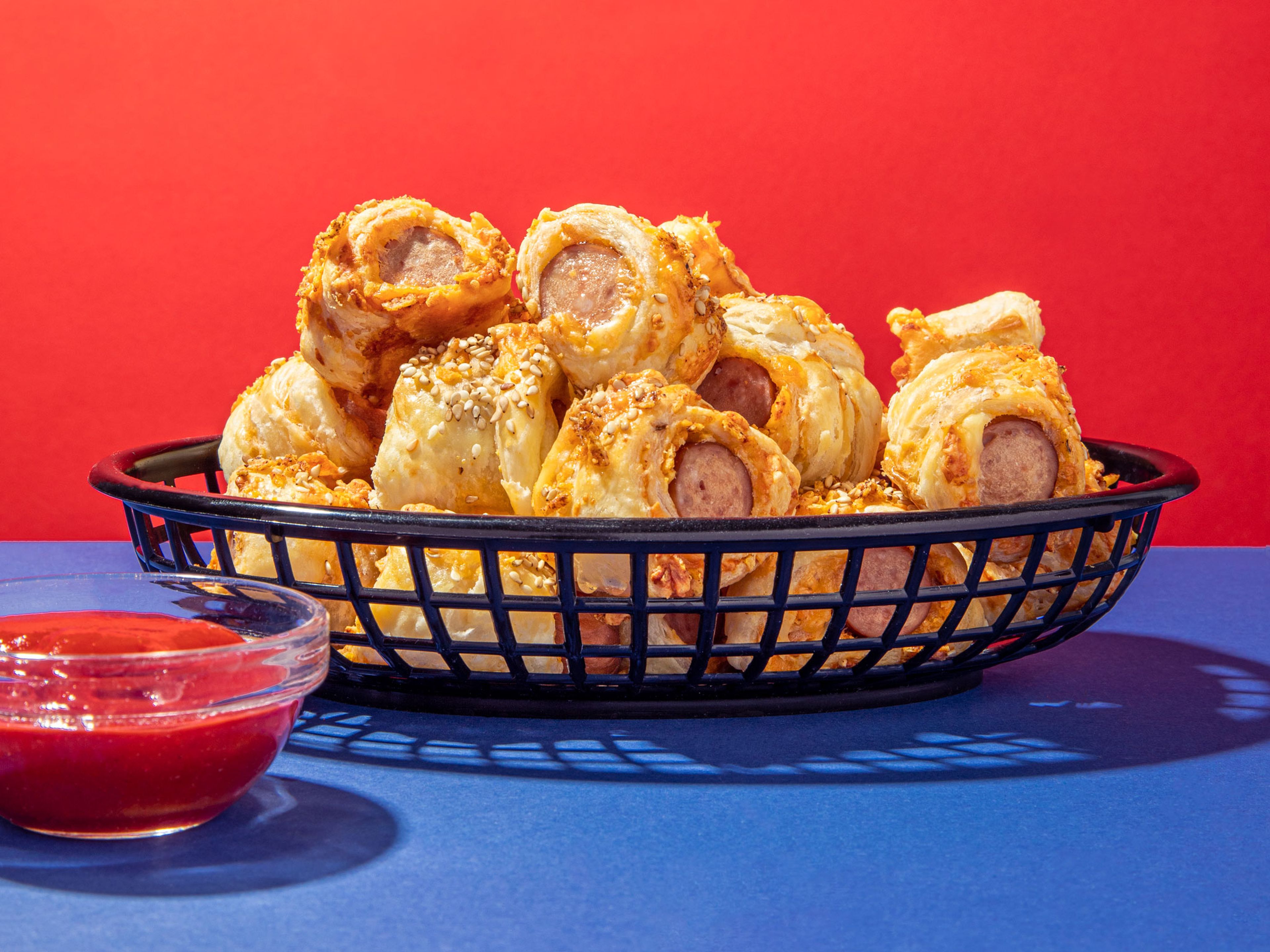 Cheesy pigs in a blanket with spicy ketchup