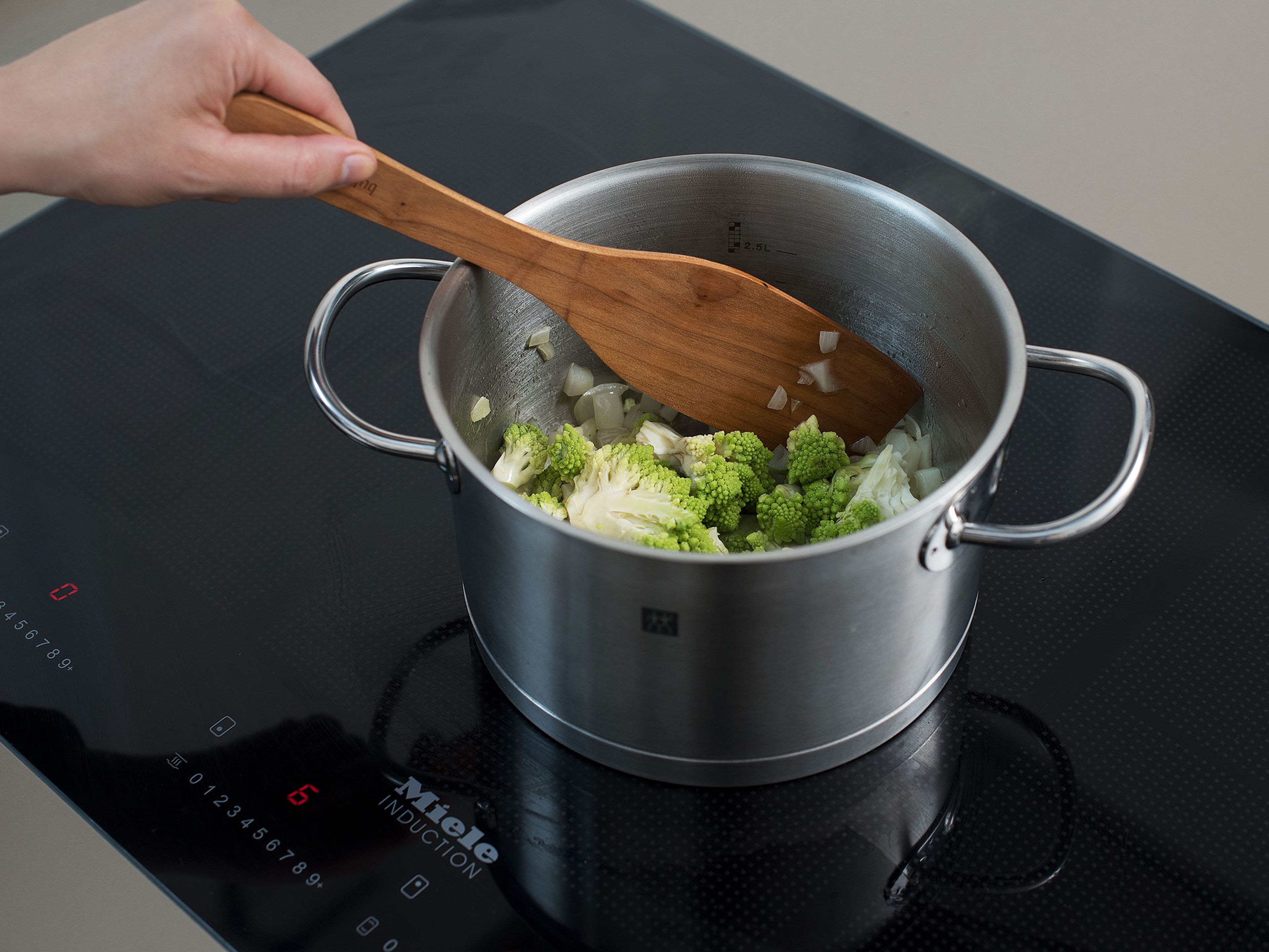 Heat the olive oil in the pot over medium-high heat and sauté the onion for approx. 1 min. Reduce heat, add Romanesco, and fry for approx. 3 min. Add the bay leaf and turmeric, then add coconut milk and water. Add salt to taste and simmer for approx. 15 min.
