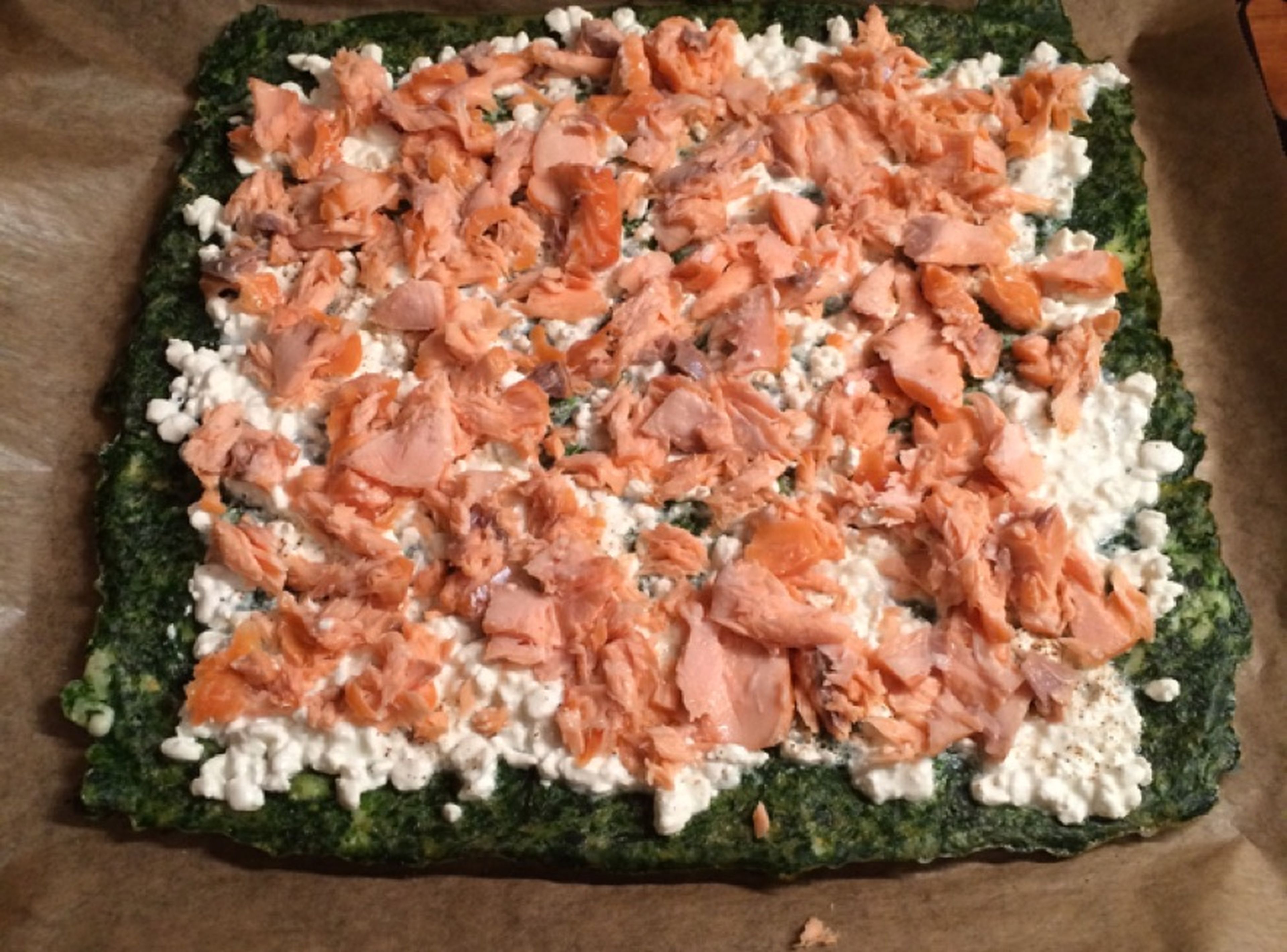 Spread the cottage cheese on top of the spinach layer and add an even layer of smoked salmon. Roll up gently into a log.