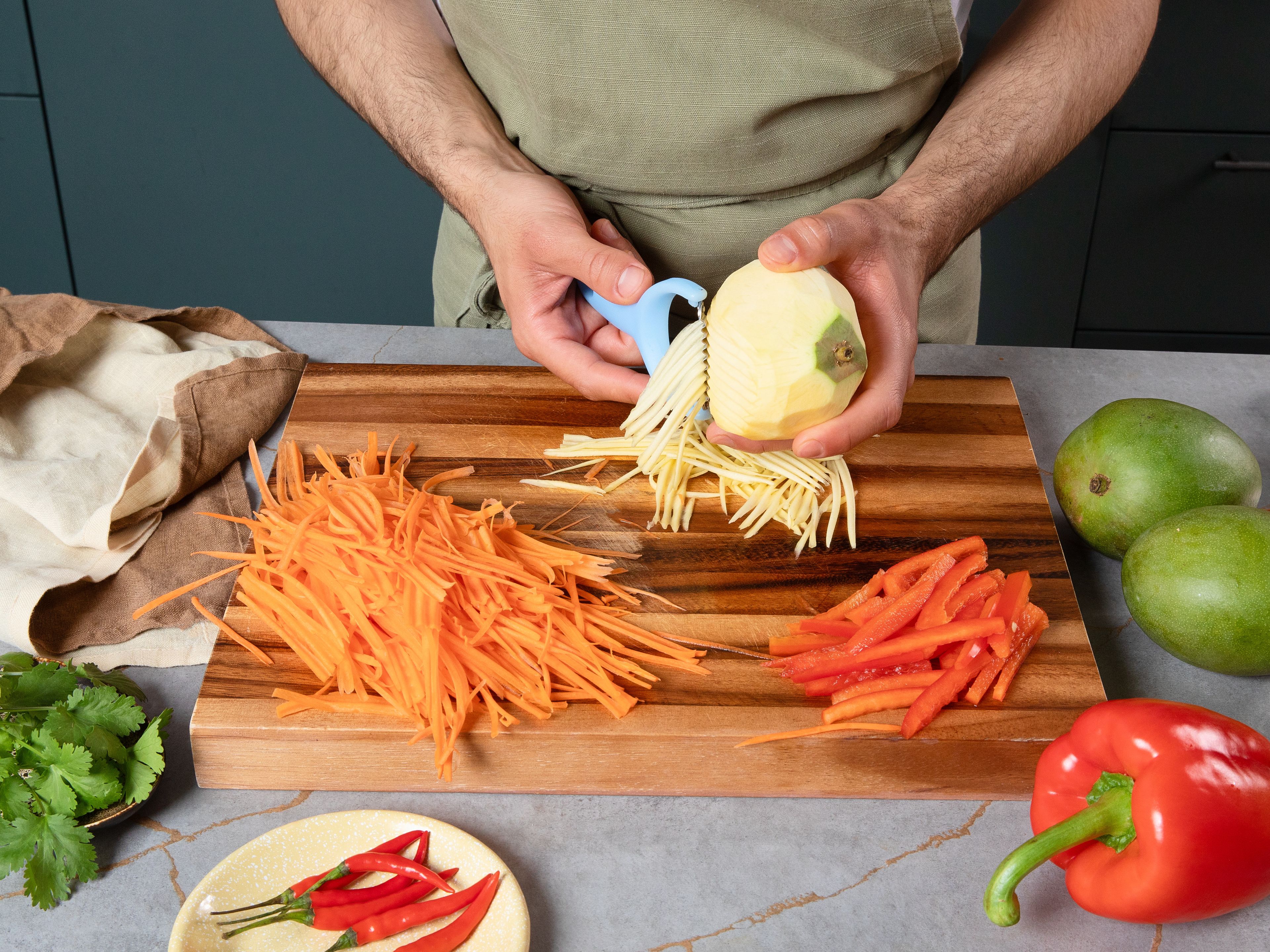 Peel mangos and carrot and slice into thin strips with a julienne peeler or knife. Deseed bell pepper and cut into fine strips as well. Peel and finely dice shallots. Cut chili diagonally. Roughly chop coriander and mint. Add all chopped vegetables into a big bowl.