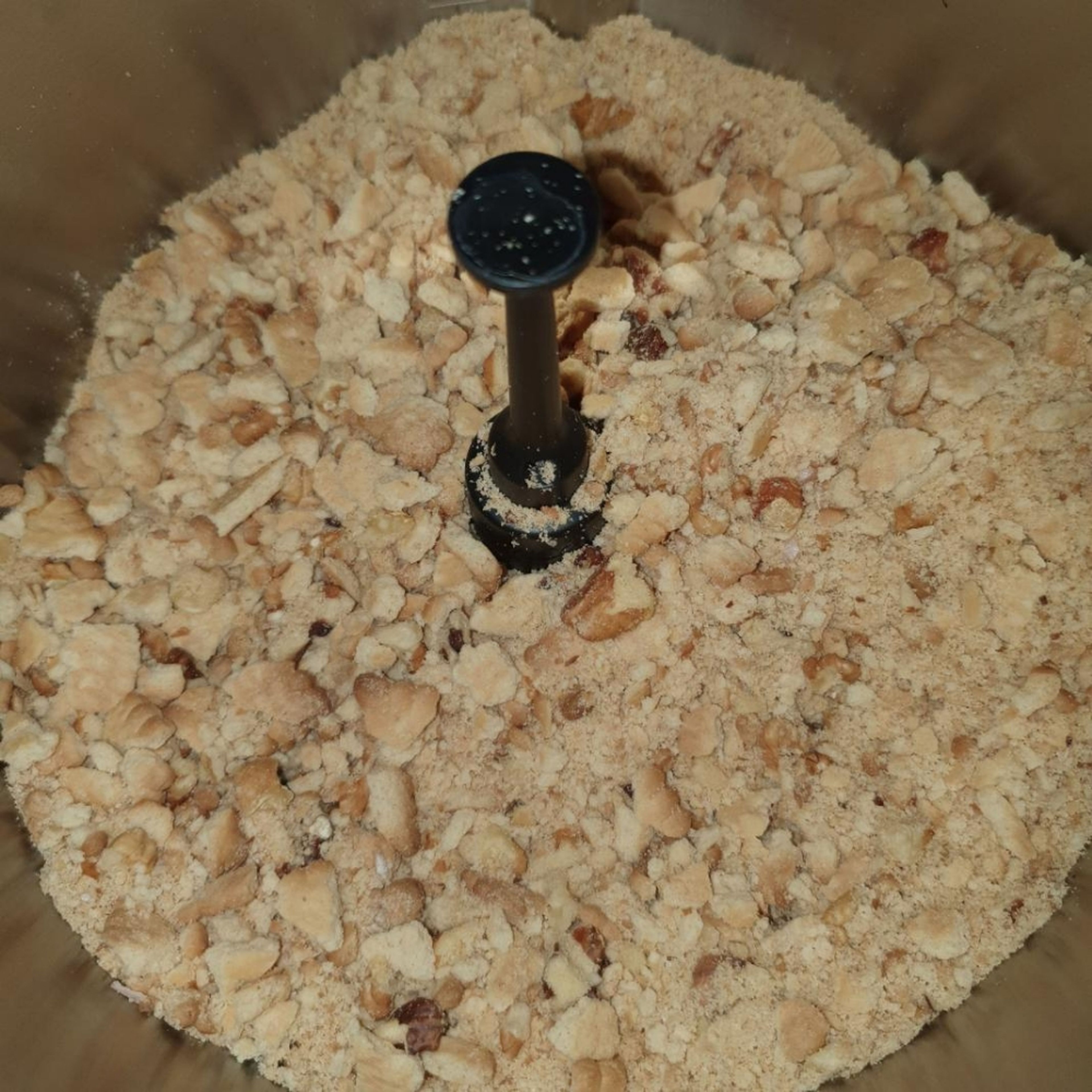 Universalmesser einsetzen. Nüsse in den Mixtopf tun. Kekse mit der Hand etwas zerkleinern und in den Mixtopf tun. Manuelles Kochen einstellen und bei geschlossenem Deckel und eingesetztem Messbecher alles klein mixen (Universalmesser | Stufe 11 | 15 Sek.). Keksmischung in eine separate Schüssel tun und zur Seite stellen. Topf waschen, abtrocknen und wieder einsetzen.