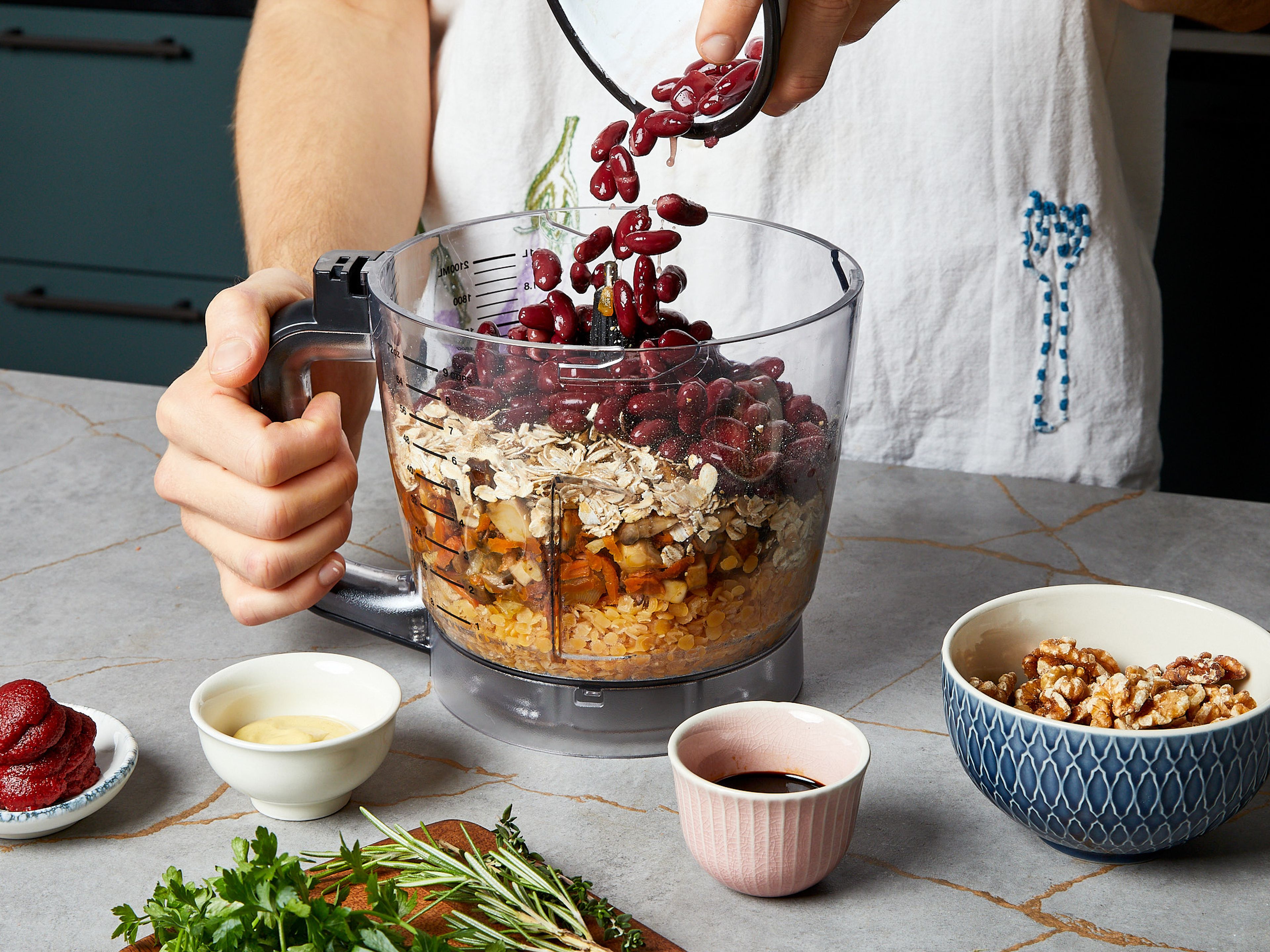 Preheat oven to 200°C/390°F convection. Put cooked red lentils, fried onions, mushrooms, carrot, and garlic in a food processor to coarsely puree with rolled oats, kidney beans, walnuts, thyme, rosemary, parsley, tomato paste, mustard, soy sauce, and a little salt and pepper until only a few small chunky pieces remain. The mixture should be sticky and hold together well. If it is a little dry, add approx. 2 tbsp of water each time, if it is too moist, blend more rolled oats in.