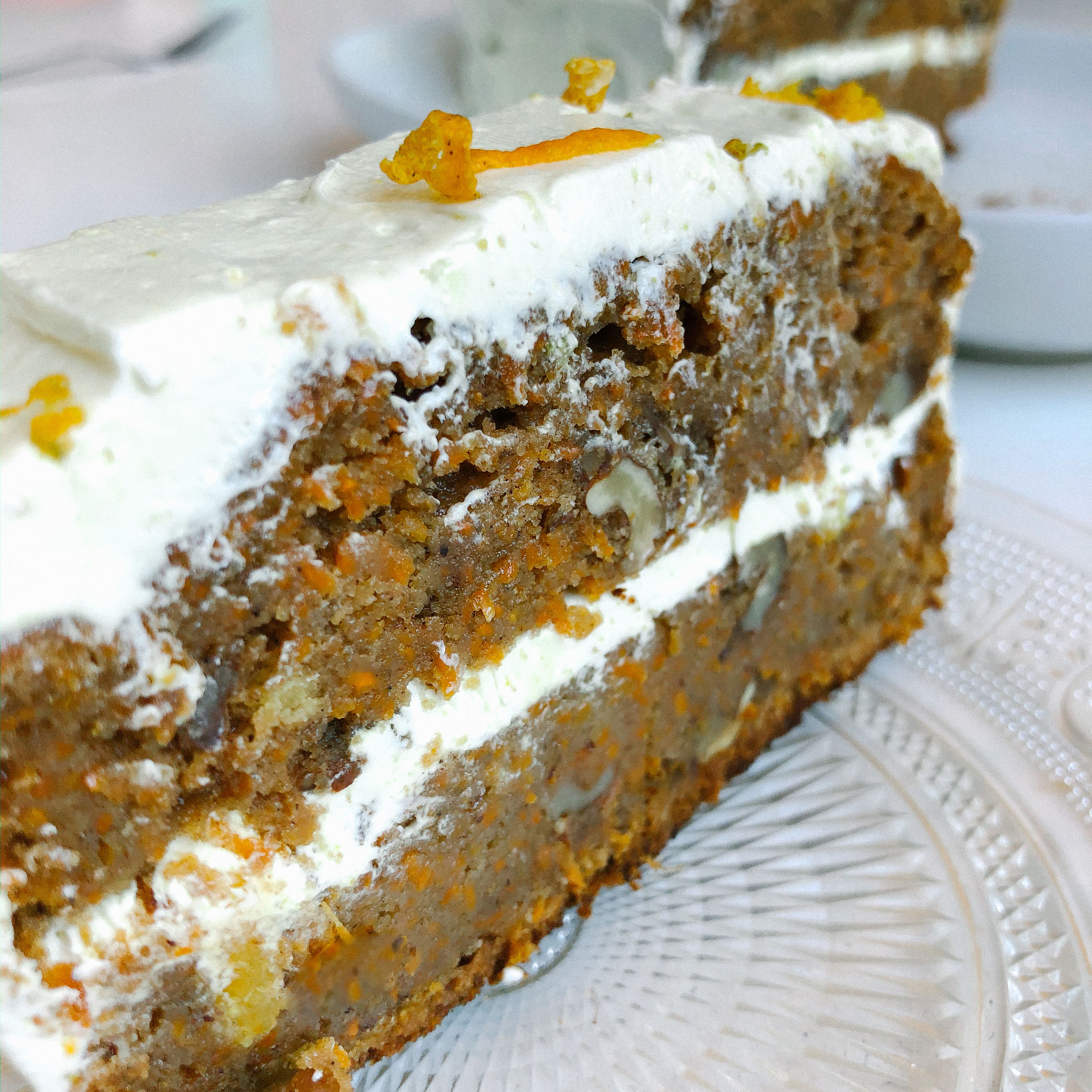 Once the carrot cake is out of the oven and at room temperature, decorate with the frosting and orange or walnut zest.