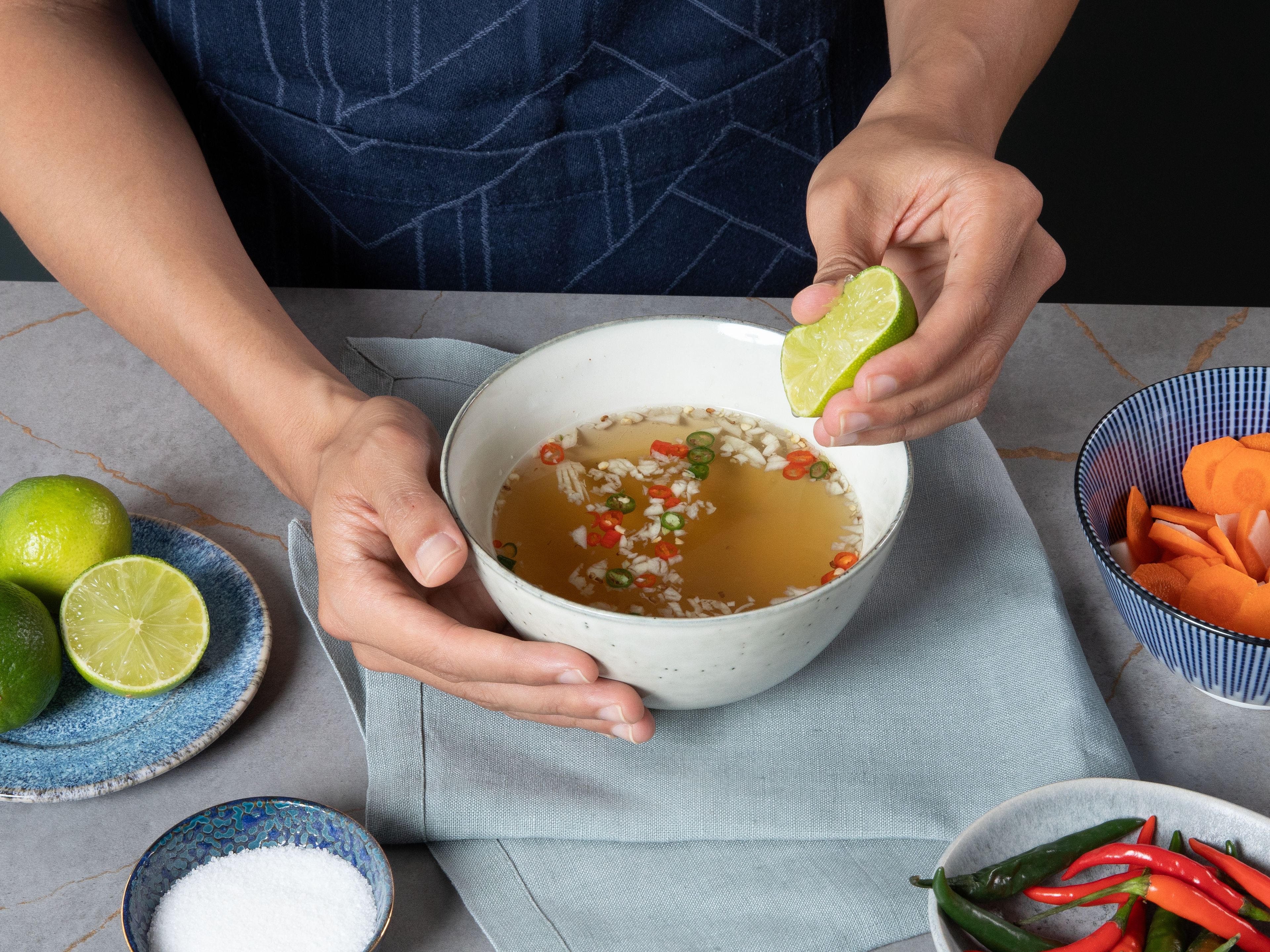 Für das Dressing Fischsoße, Wasser, Zucker, Limettensaft, die Thai-Chili und den restlichen Knoblauch in einer Schüssel verrühren, bis sich der Zucker vollständig gelöst hat. Zum Schluss alle Komponenten zusammen anrichten und servieren.