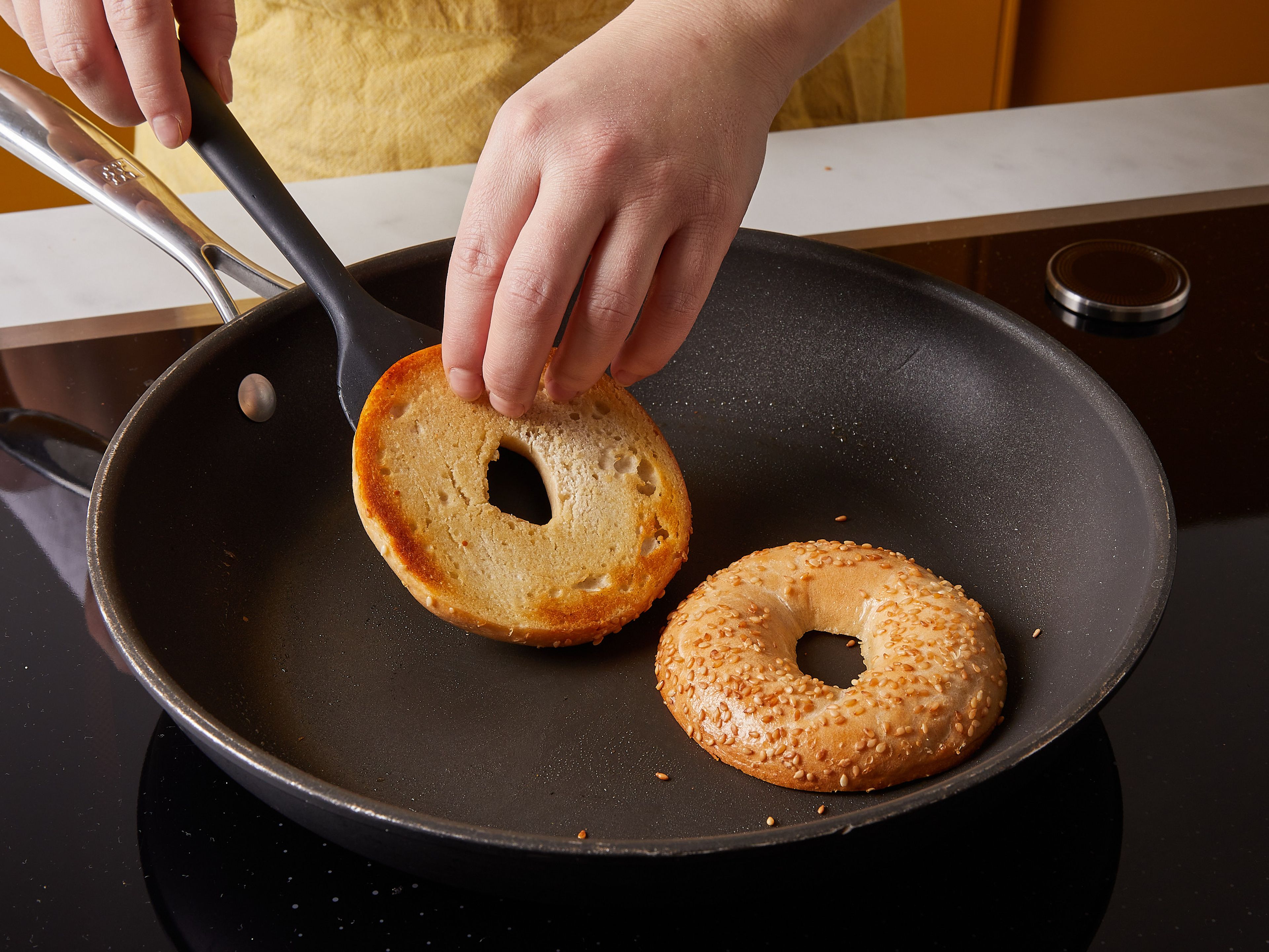 In a small nonstick frying pan, heat half the butter over medium-low heat, add bagel, cut-sides down, and toast briefly.