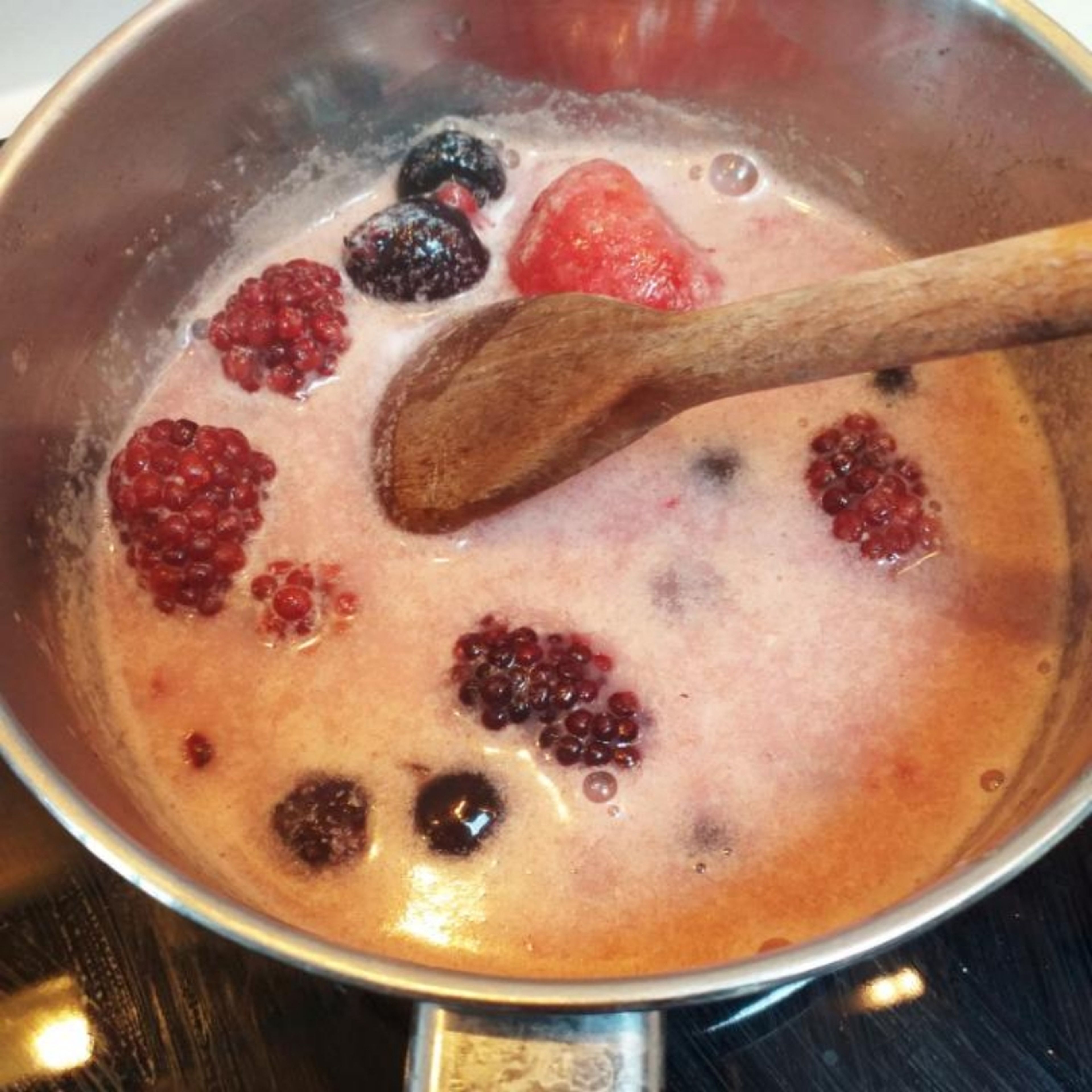 When the milk starts the first boil, remove from the fire and add the mix of berries. Mix it and let it rest.