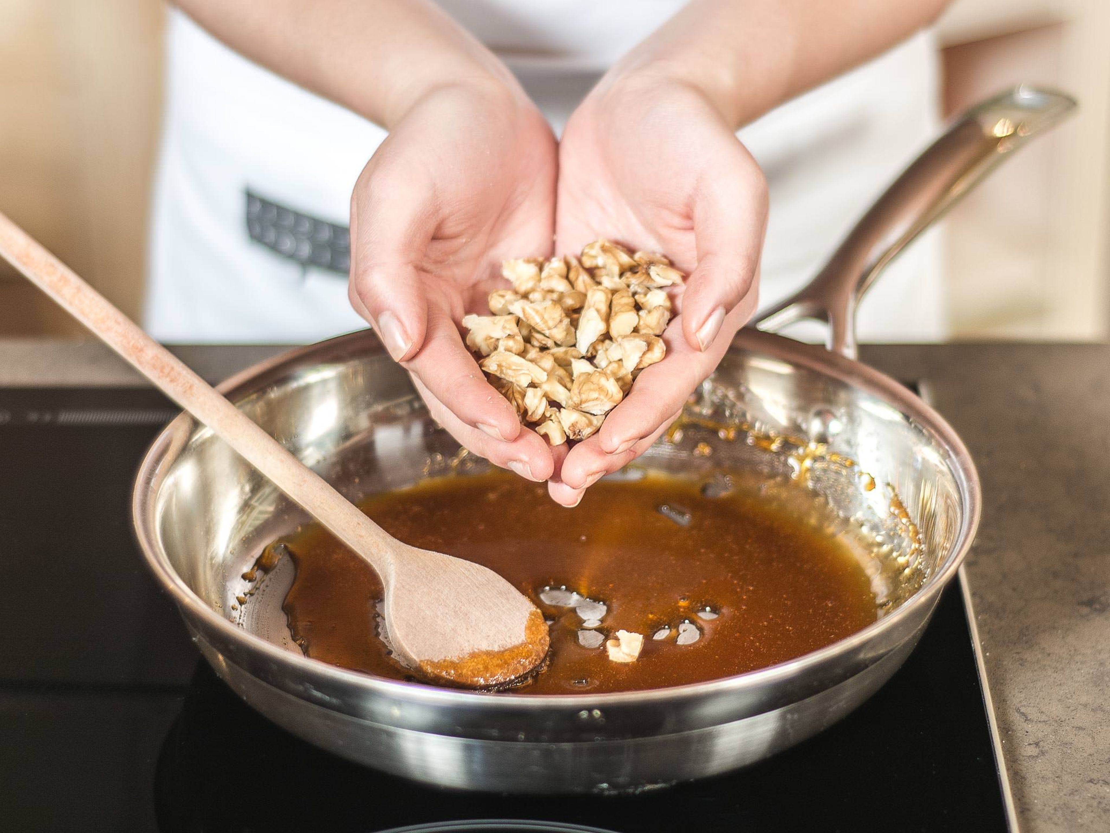Caramelize sugar in a frying pan until amber colored. Next, add chopped walnuts and stir into the caramel.