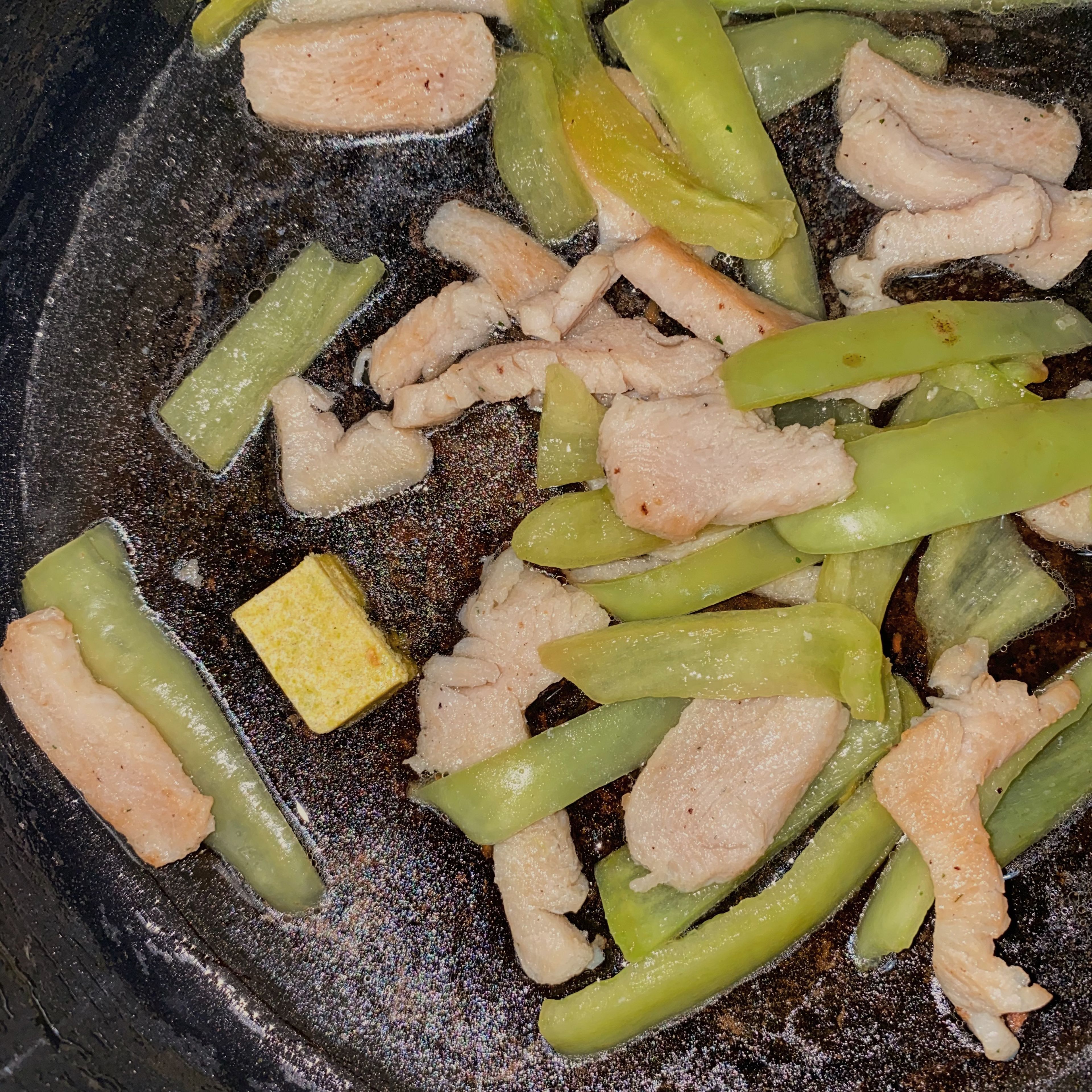 To the chicken and the pepper in the pan add water and chicken stock powder or half of chicken bouillon cube